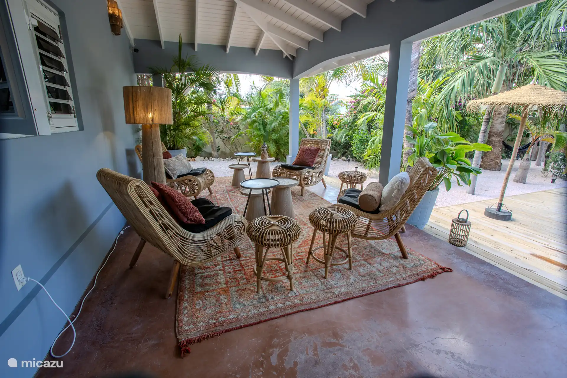 Una zona lounge encantadora con 4 sillones de ratán y mesas agradables