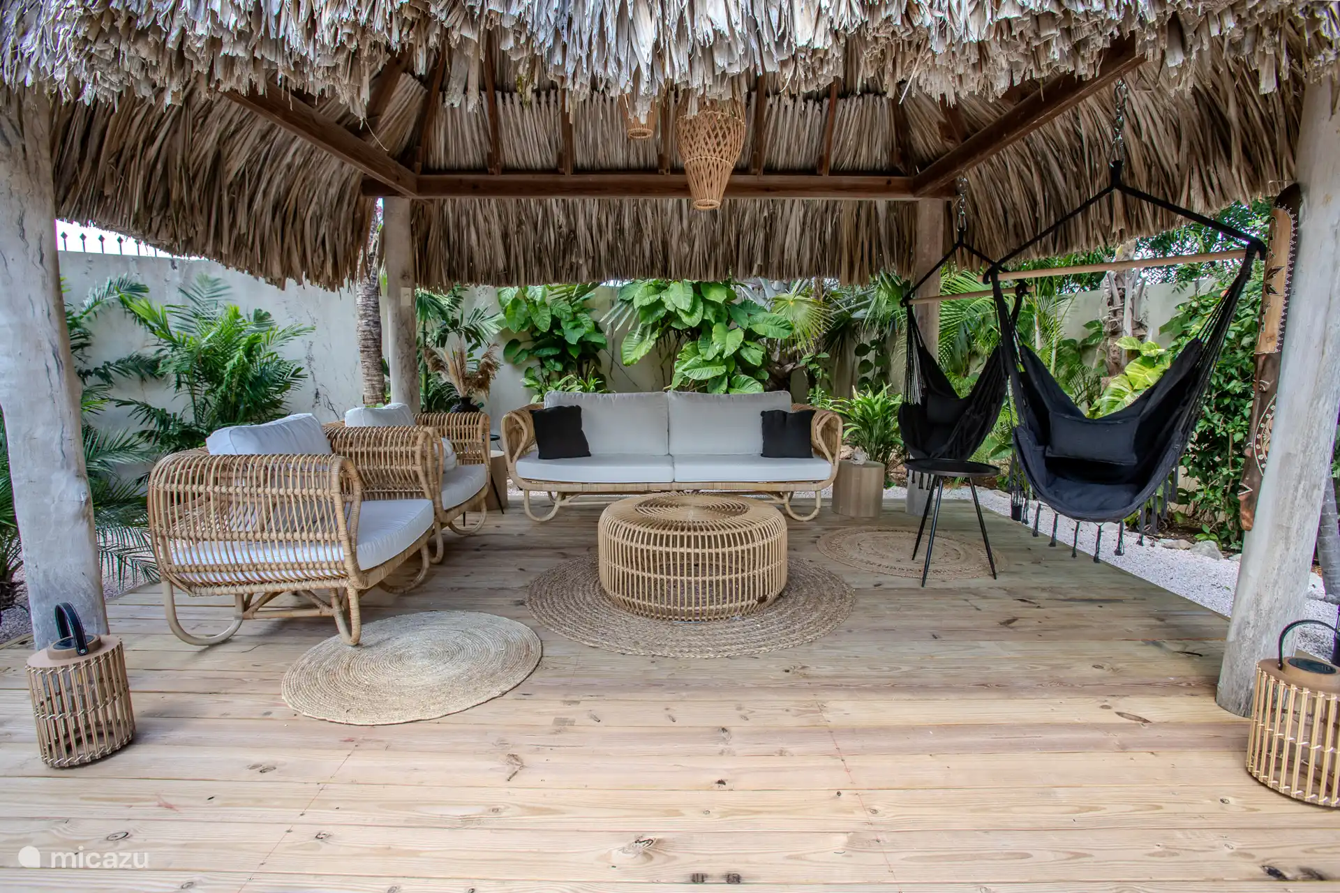 La palapa tiene un cómodo sofá de ratán y hay 2 sillones colgantes 
