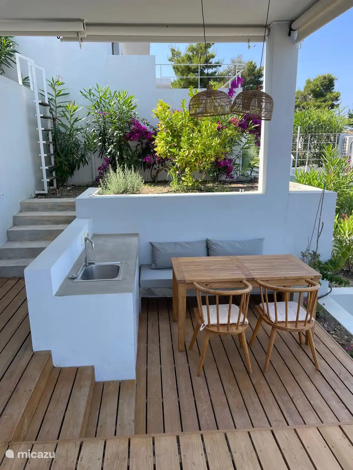 De Griekse tuin en de buitengootsteen met de eettafel en zithoek