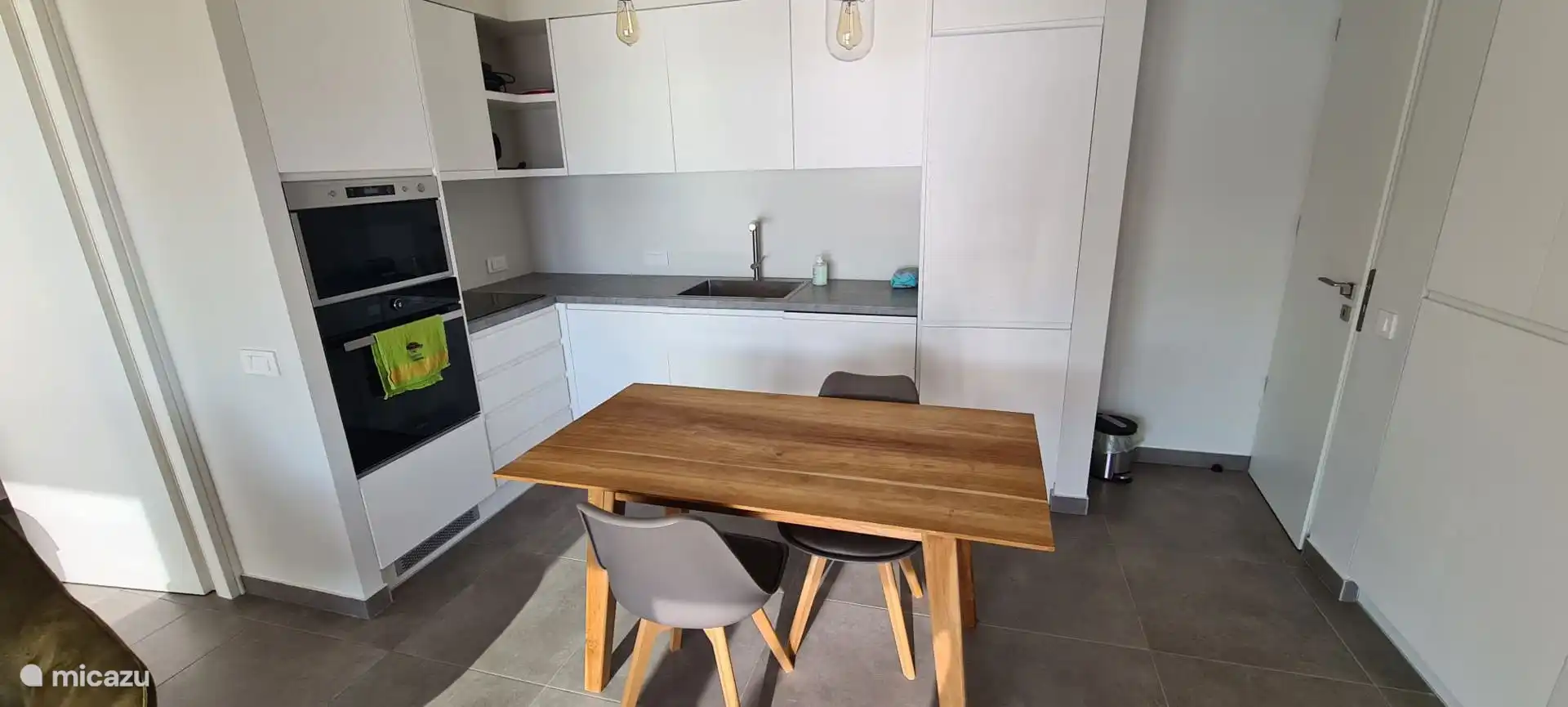 De open keuken, volledig uitgerust met oven, magnetron, koelkast, vaatwasser, wasmachine...