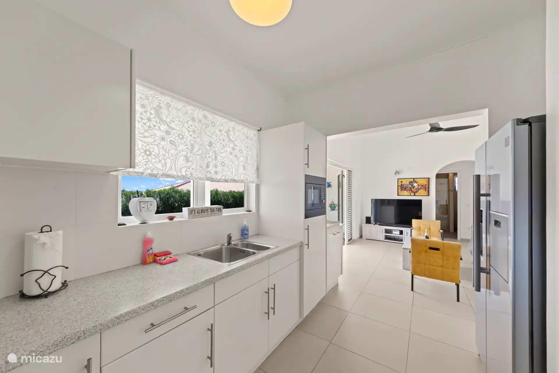 Vanuit de ruime keuken is er uitzicht op de porch en zwembad. 