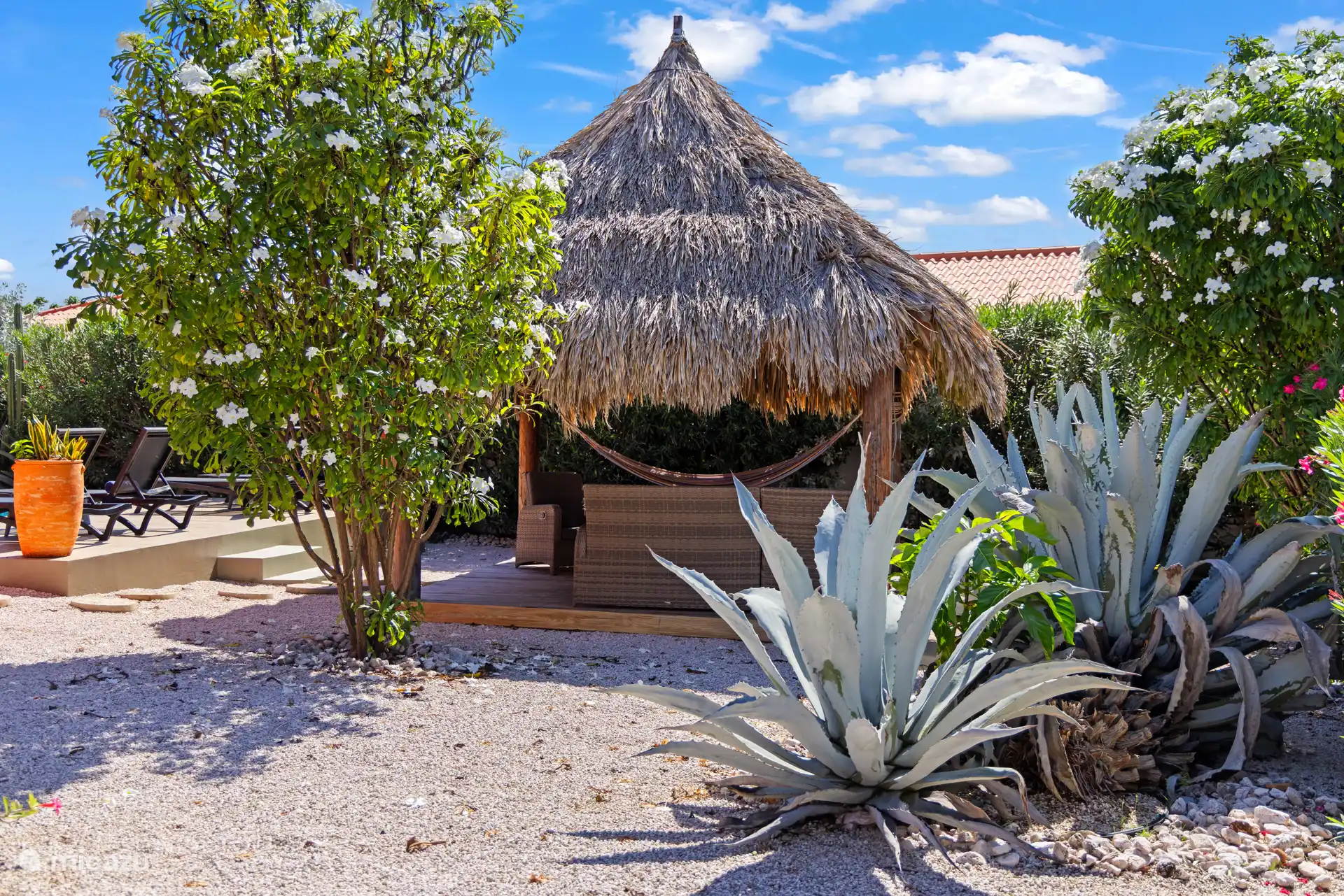 De palapa met hangmat en loungeset. 
