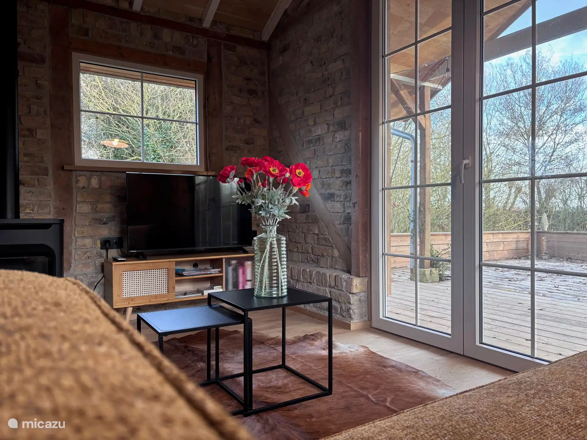 Wohnzimmer mit Smart-TV und Terrassenblick