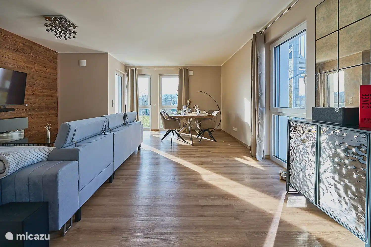 Heller, großzügiger Wohn- und Essbereich mit viel Tageslicht, gemütlicher Couch und stilvollem Esstisch – ideal zum Entspannen und Zusammensein.