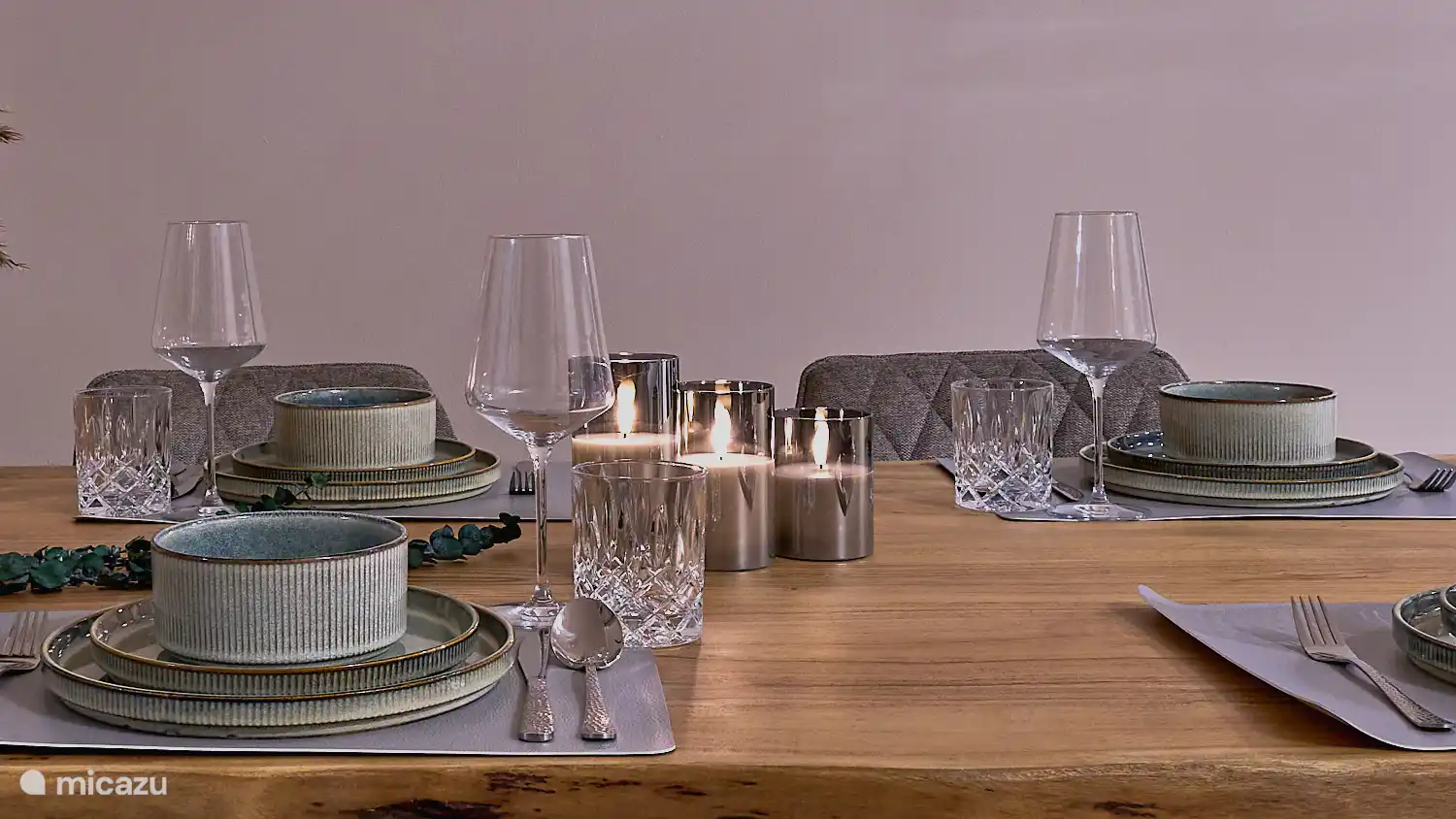 Liebevoll gedeckter Esstisch mit hochwertigem Geschirr und stimmungsvoller Beleuchtung – perfekt für gemütliche Mahlzeiten.