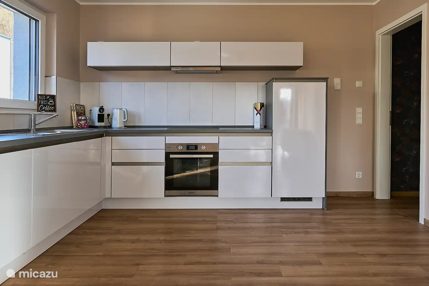 Moderne, voll ausgestattete Küche mit Backofen, Kochfeld, Kühlschrank und viel Arbeitsfläche – ideal für Selbstversorger.