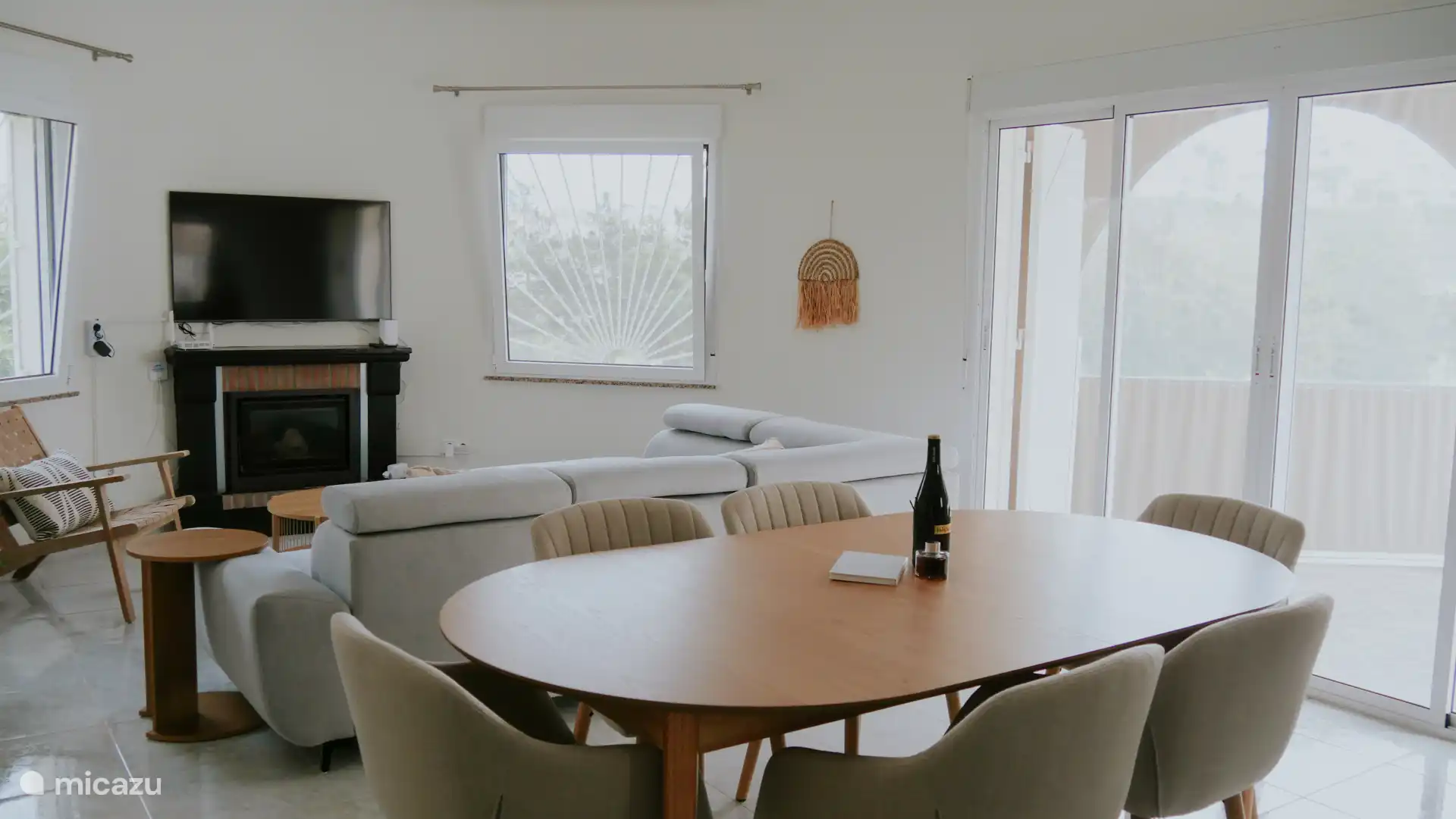 Woonkamer met een uitschuifbare eettafel voor 6 tot 8 personen, waarin zowel de haard als de tv duidelijk in het zicht staan