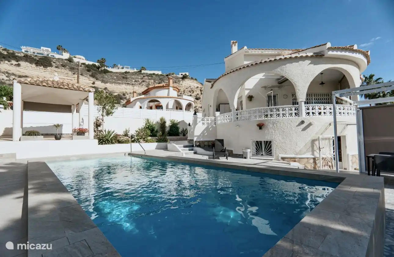 Zwembad met het huis en bergen op de achtergrond