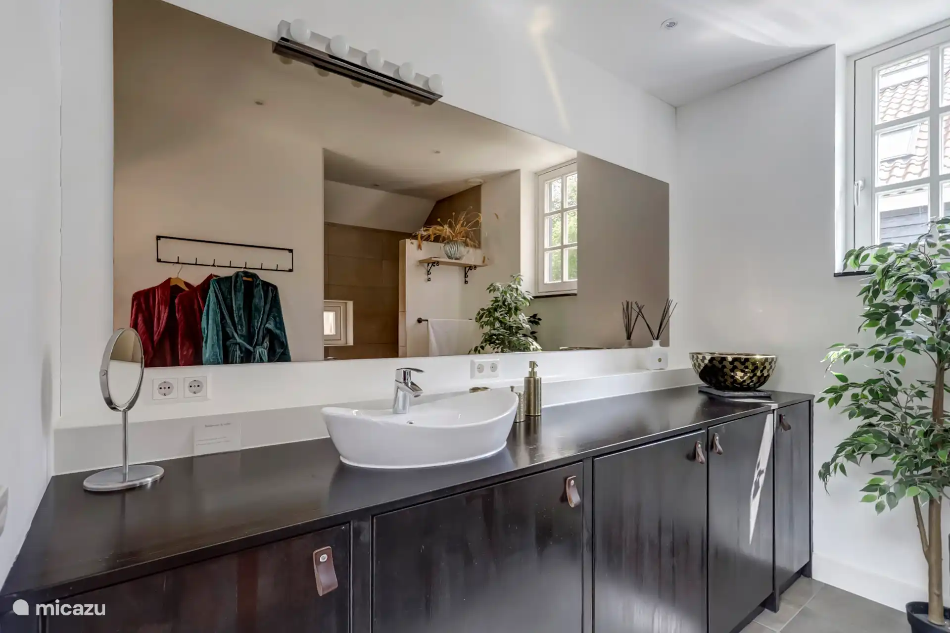 Ruime badkamer met Rituals en wasmachine