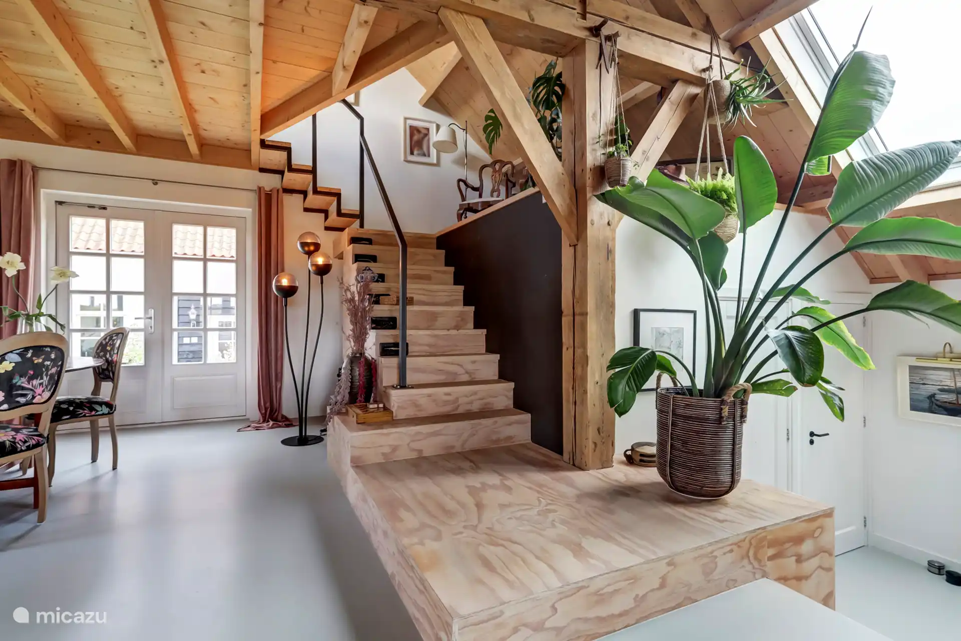 Trap naar de keuken en de slaapruimtes. Deuren van badkamer en wc.