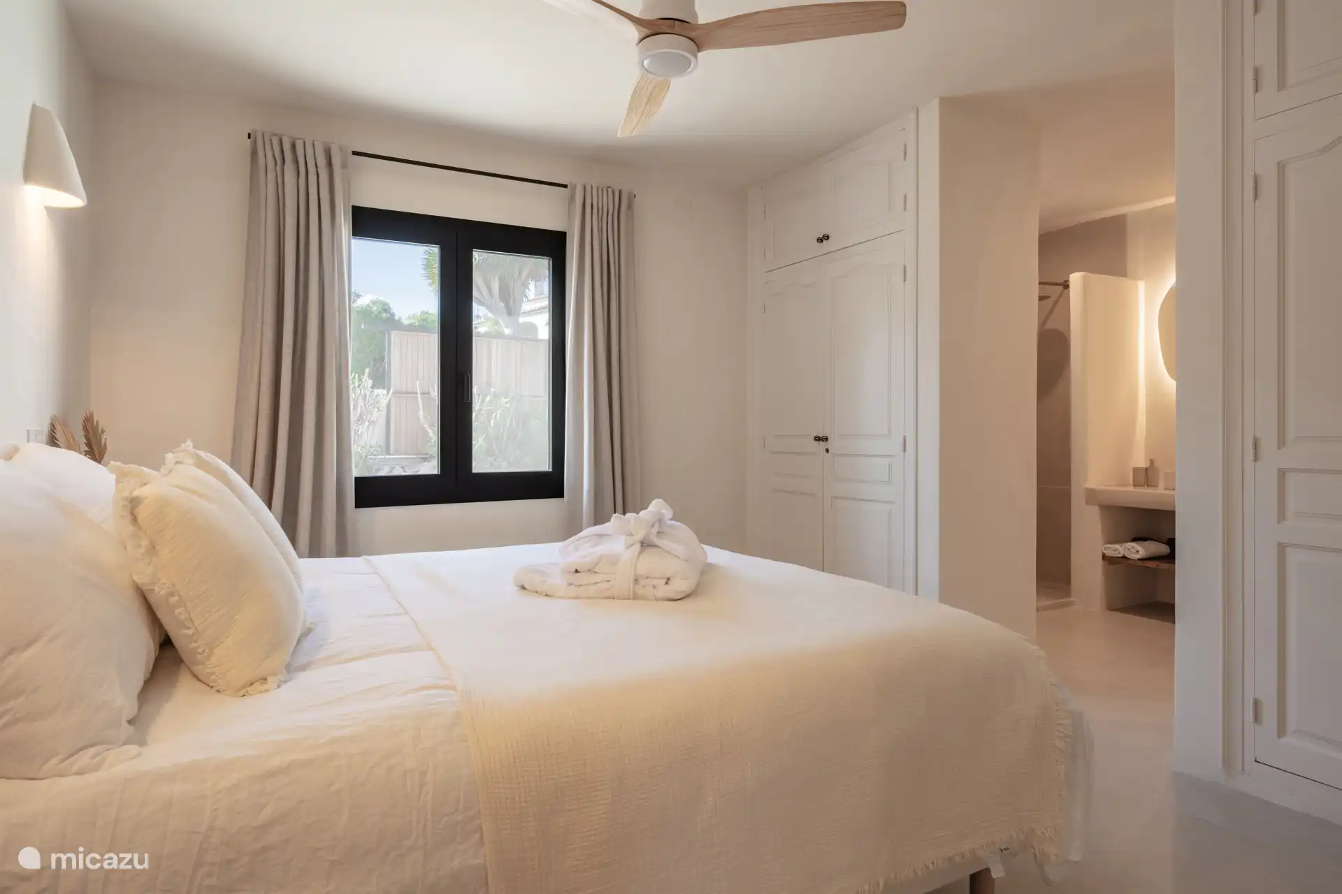 Slaapkamer met badkamer ensuite, met ligbad en inloopdouche.