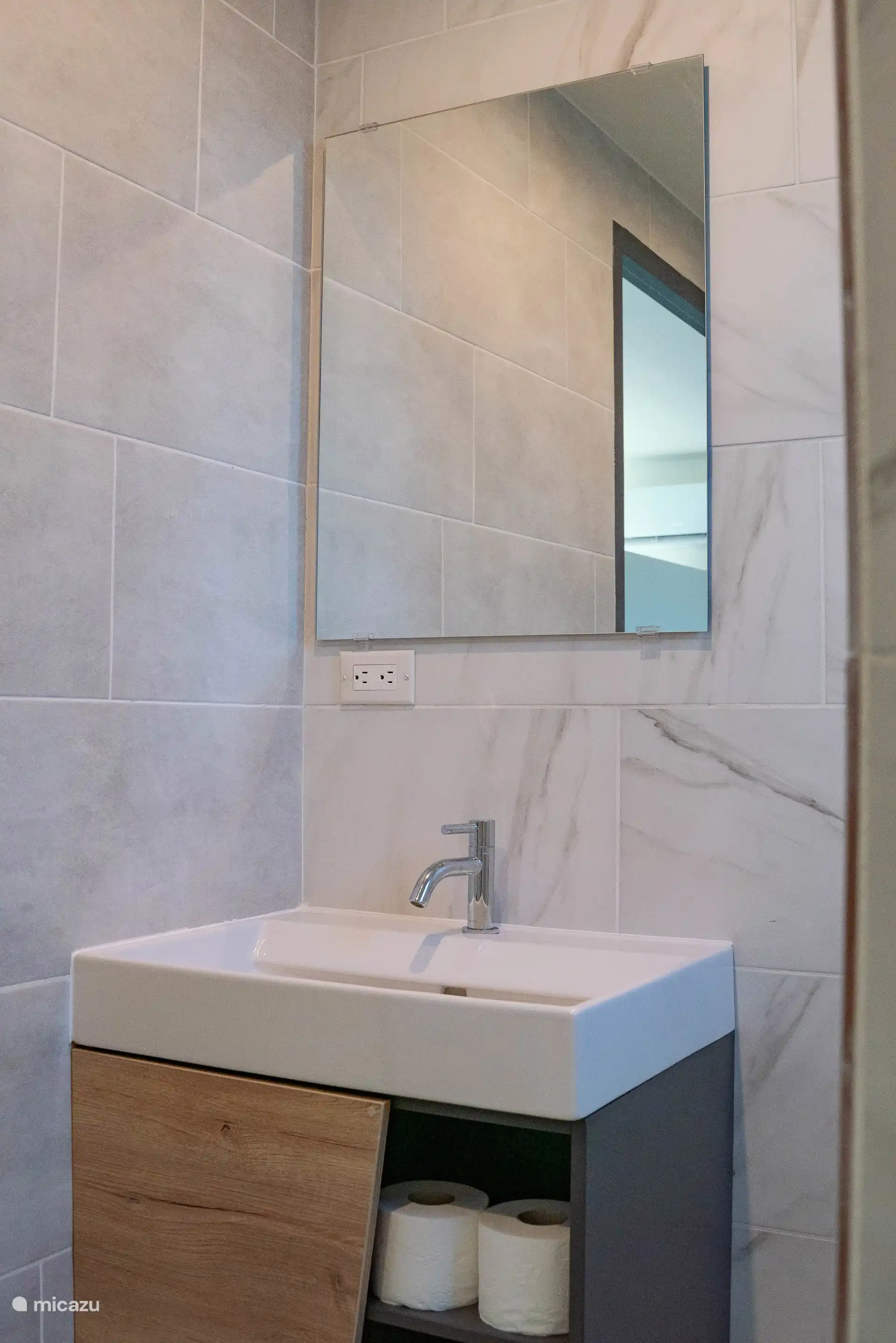 Baño con lavabo y espejo, prácticamente amueblado.