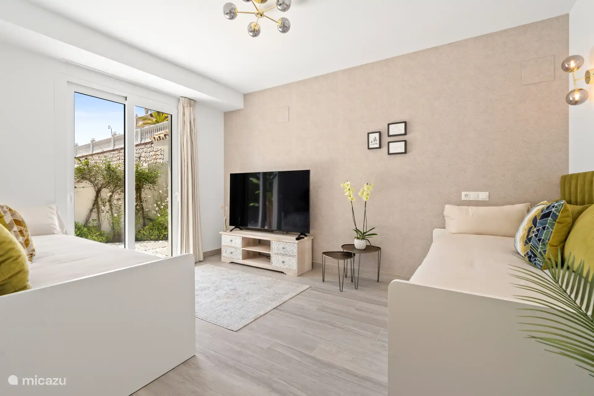 Habitación 5 con televisor de pantalla plana y acceso al jardín.