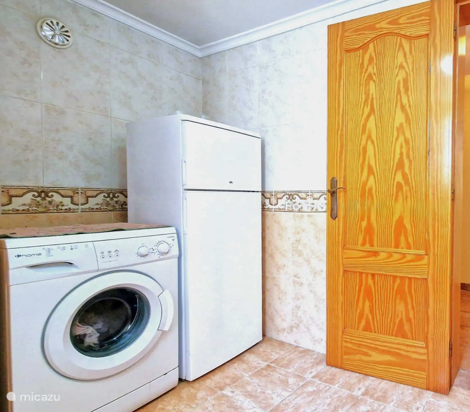 In de oranje badkamer beneden is een wasmachine en een grote extra koelkast/vriezer