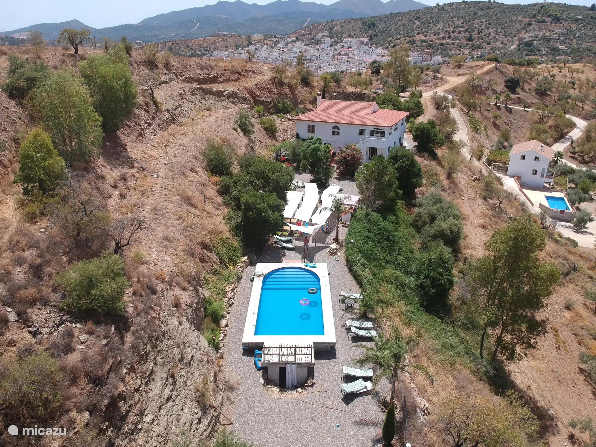 Le jardin avec le bâtiment principal est derrière, avec le village typique de Guaro et blanc andalou.