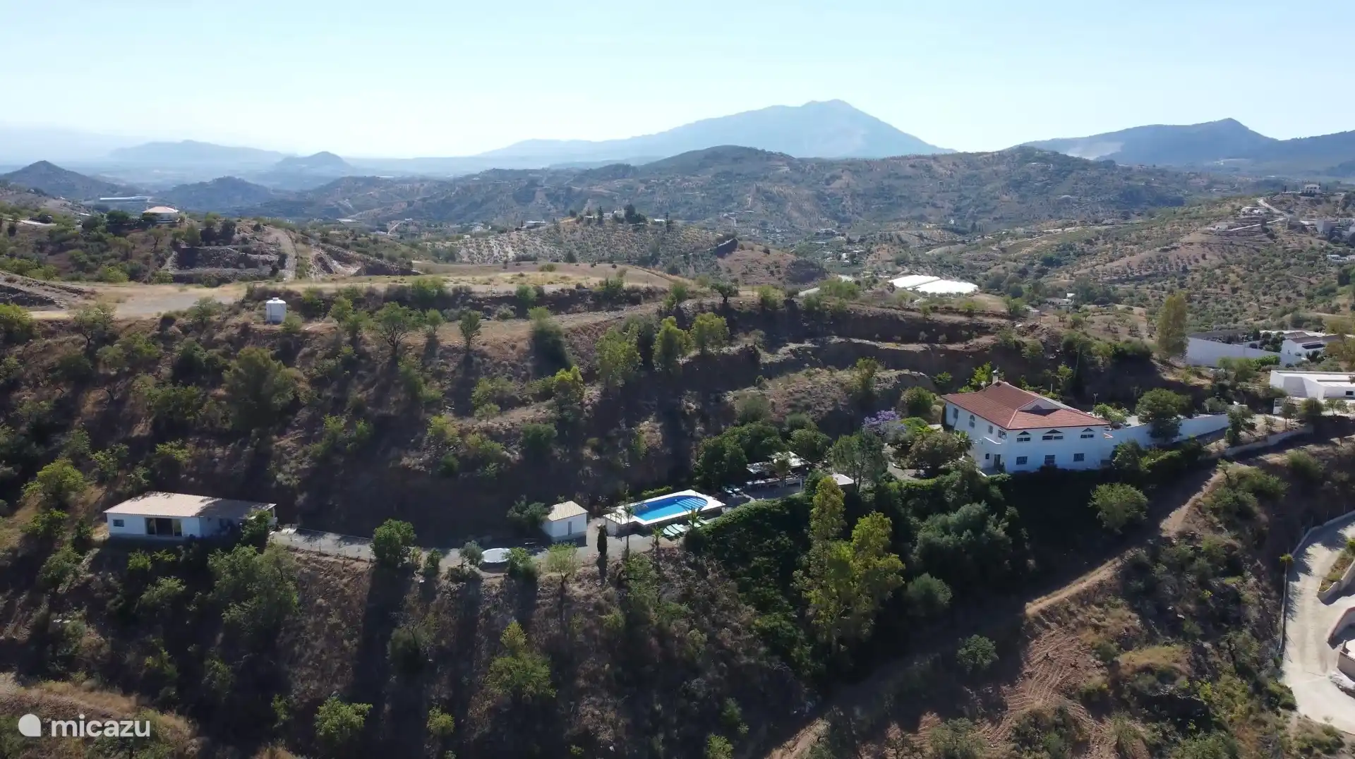 Tout Nido Aguila Blanca, avec le cottage à gauche, la piscine au centre et la maison principale avec les trois autres appartements à droite.