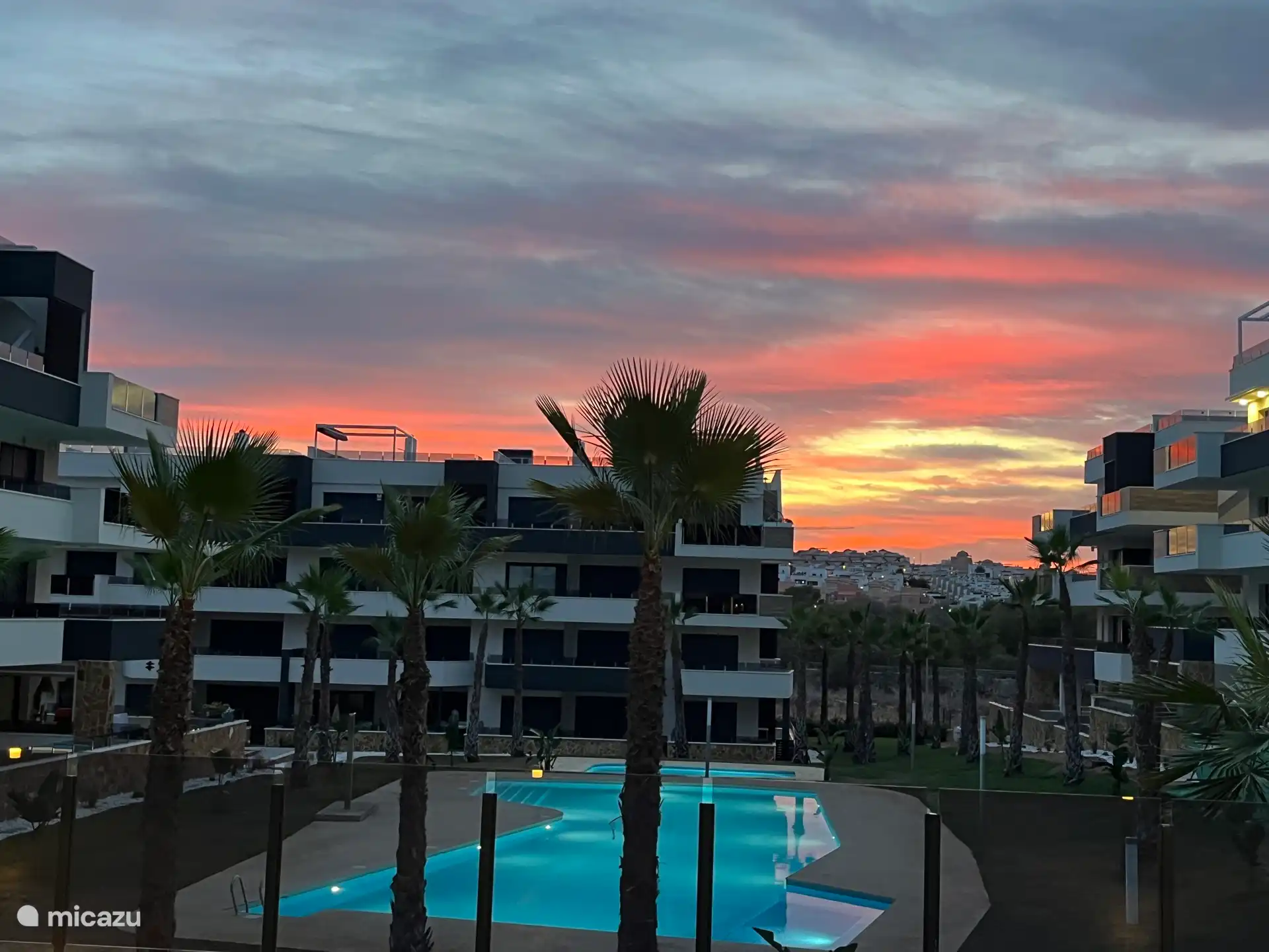 Complejo de apartamentos al atardecer. Desde la ubicación única de esta terraza se disfruta de una vista panorámica y de la colina que hay detrás.