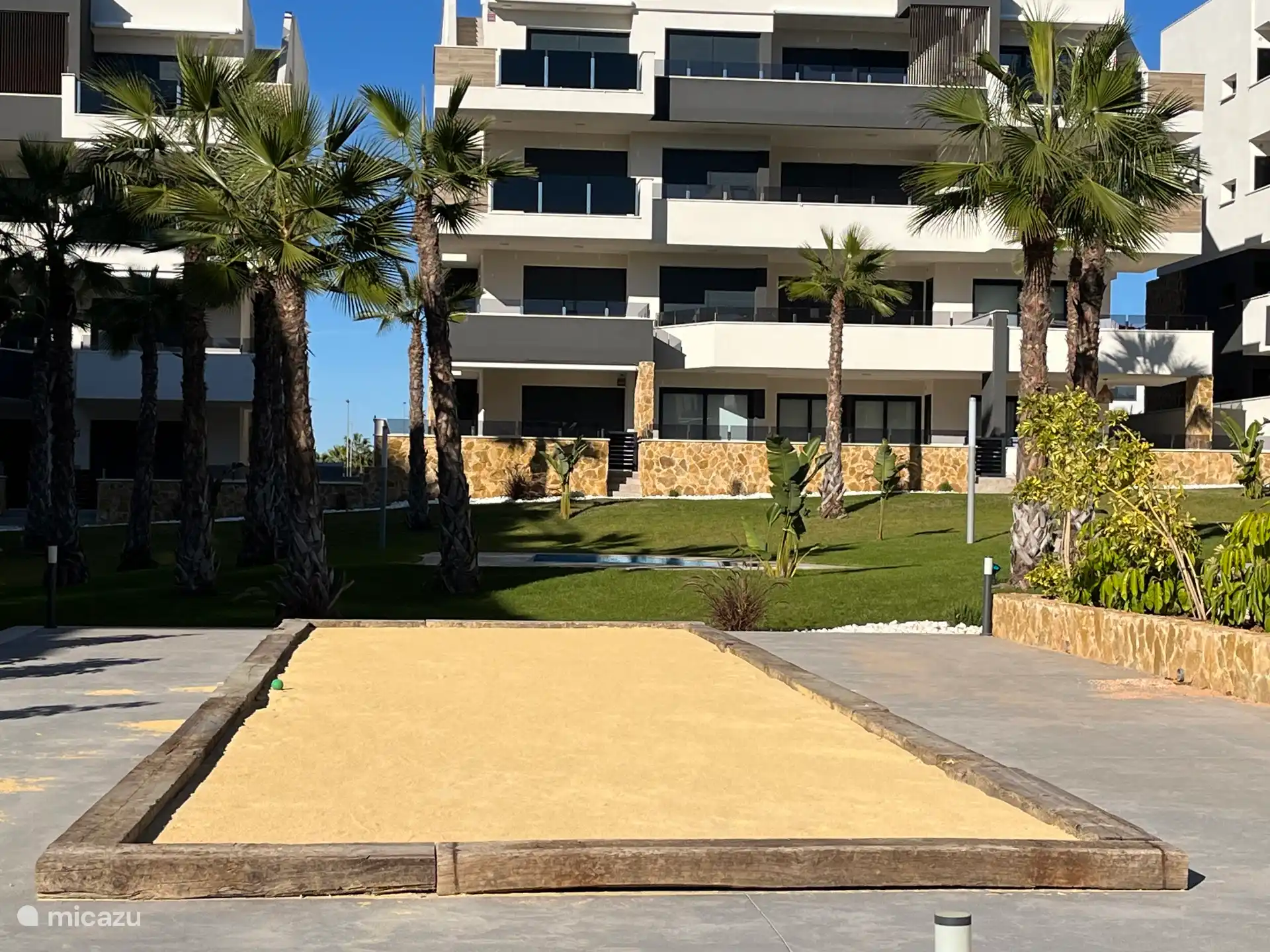 Disfruta jugando juntos en la pista de Jeu-de-boules en el jardín común.