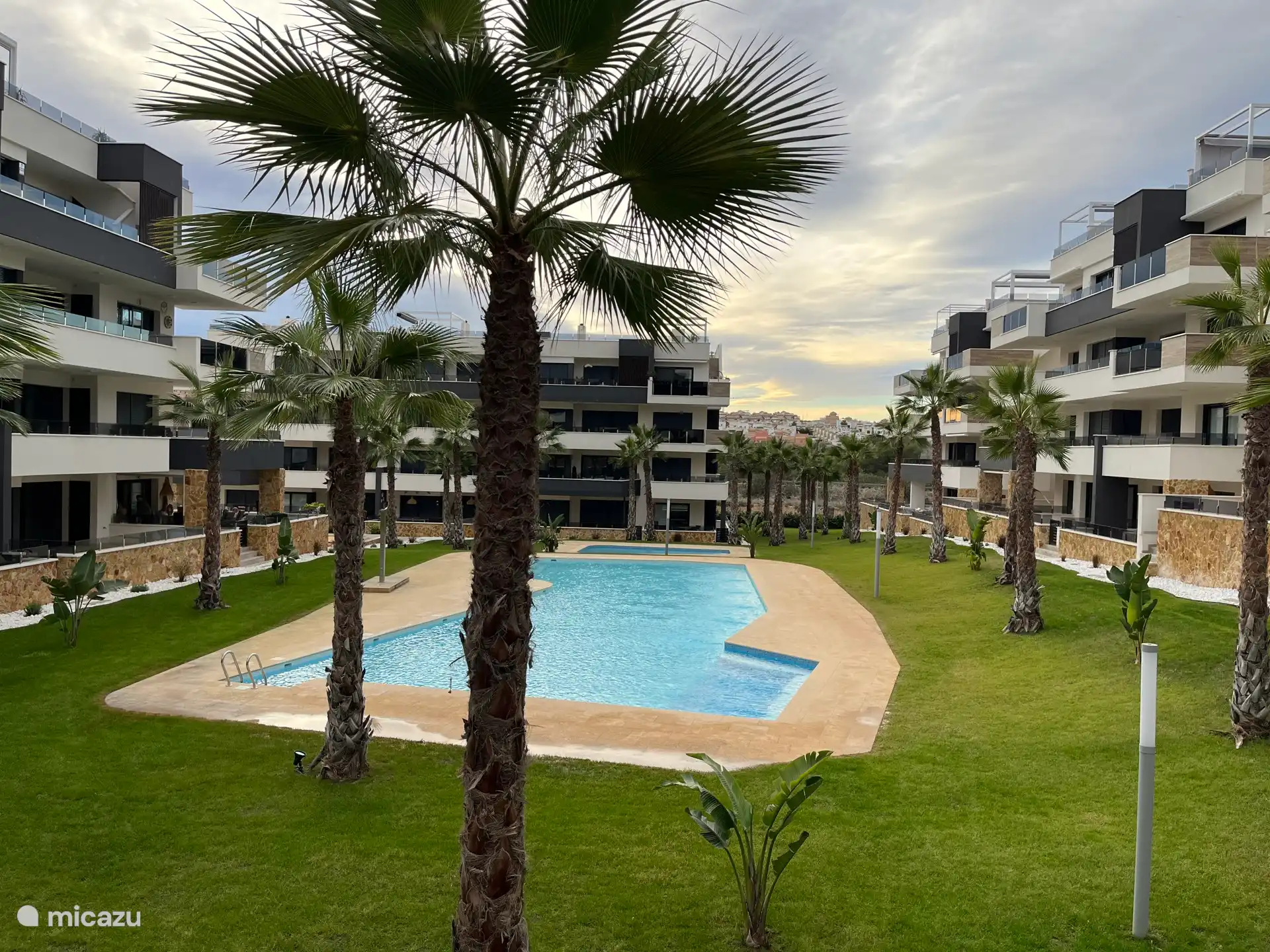 Jardín con patio bellamente ajardinado, parte del área común del acogedor complejo. ¡Disfruta de tus vacaciones aquí!