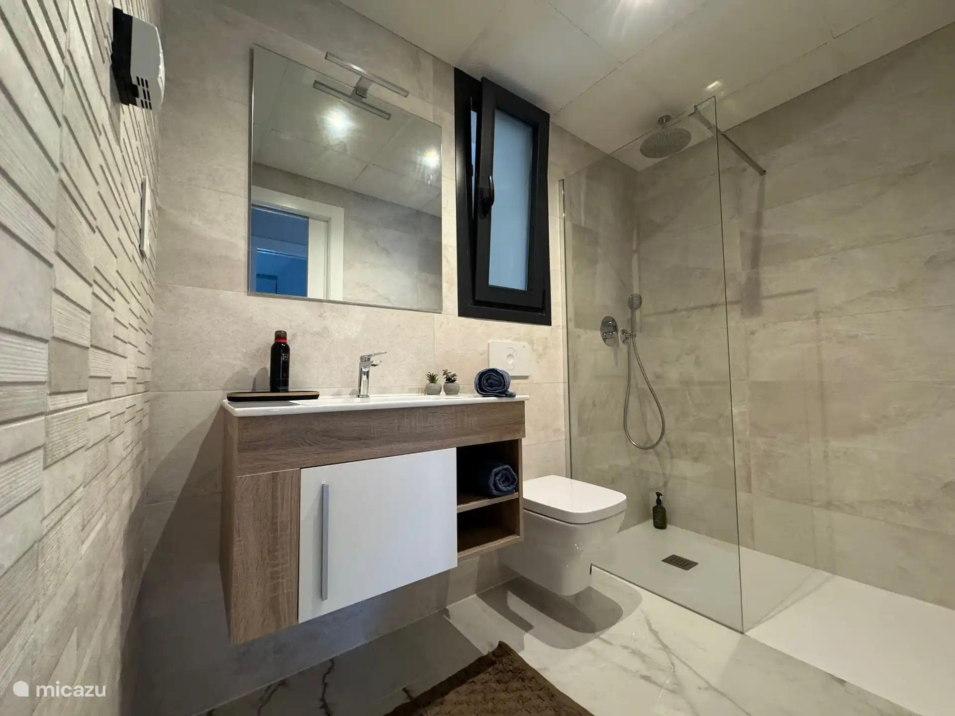 Moderno, completo, segundo baño con lavabo elegante, ducha a pie de agua, ducha de lluvia y acabado lujoso.