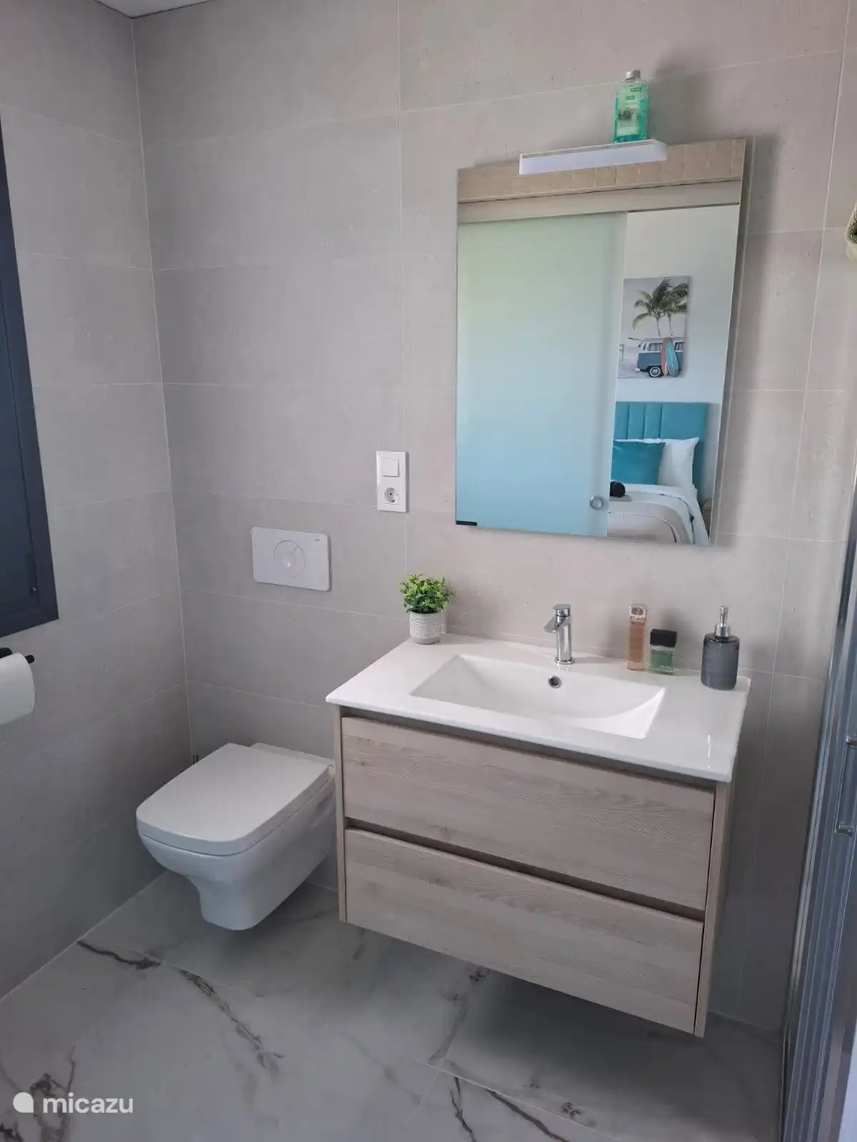 spacious ensuite bathroom with toilet, rain shower and sink belonging to master bed room