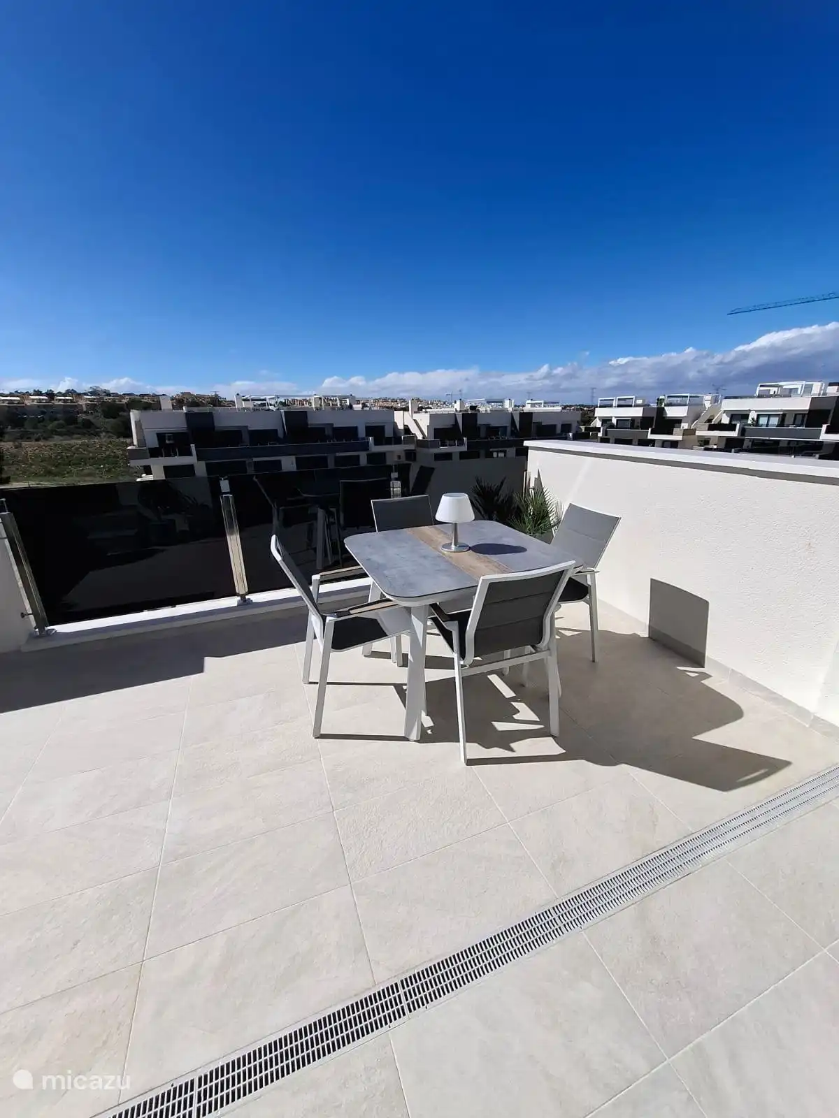 very spacious balcony with cozy table and 4 lovely chairs overlooking the communal swimming pool