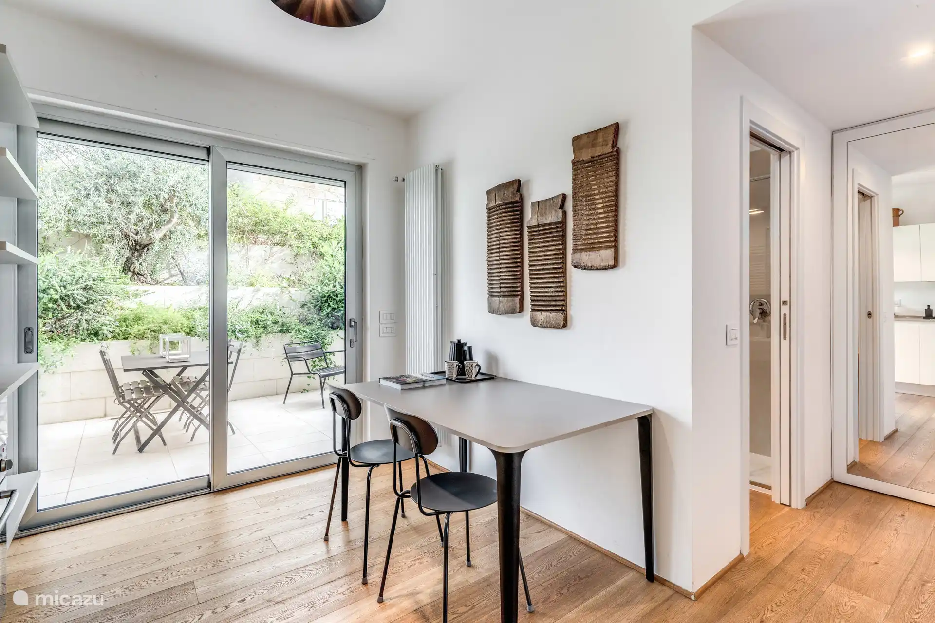 Eettafel, uitzicht op de tuin en grote spiegel.