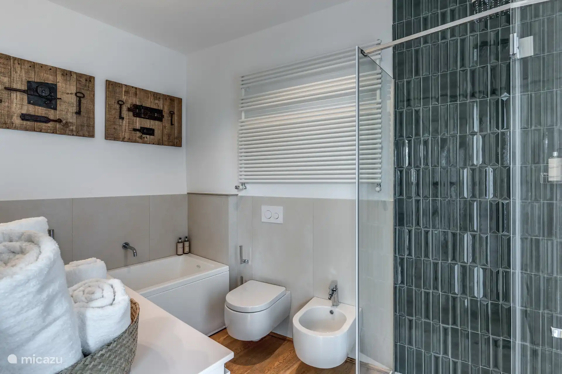 Badkamer met bidet, douche en badkuip. Badkamer met raam met uitzicht op de tuin.