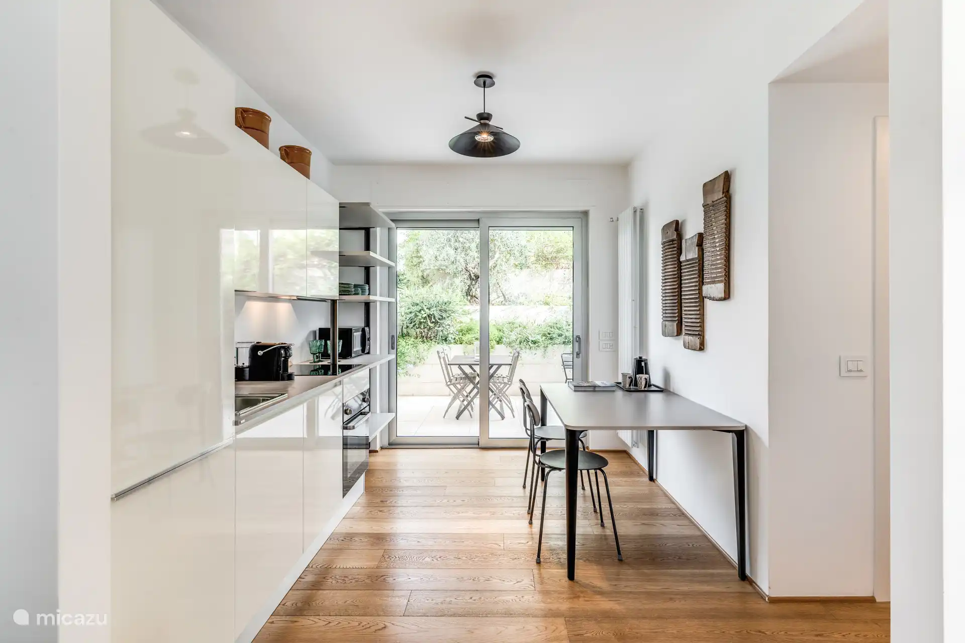 Volledig uitgeruste keuken. Eettafel en uitzicht op de tuin.