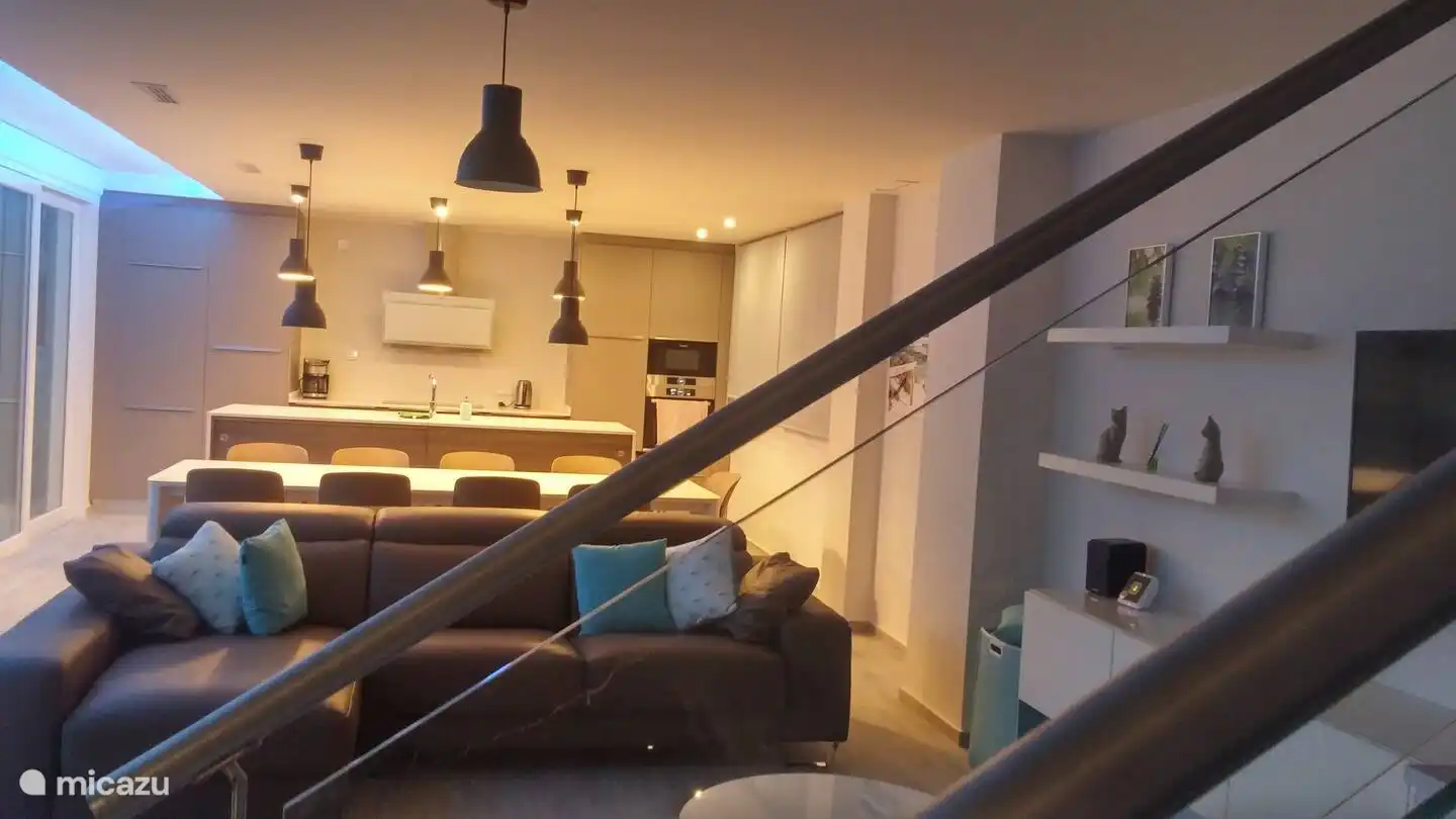 De woonkamer met grote luxueuze keuken.