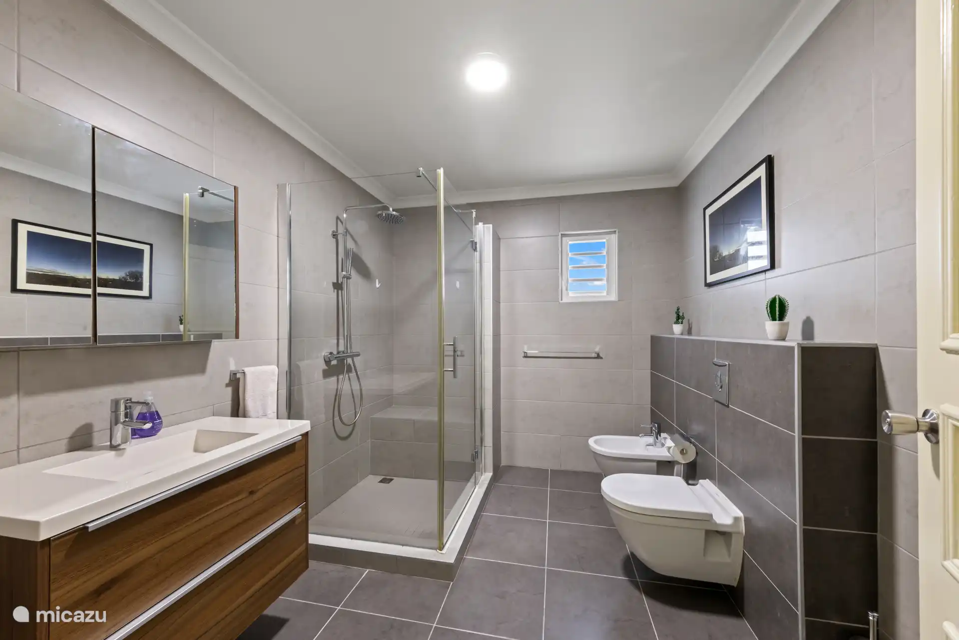 Spoeling na het strand. Badkamer 2 is ruim met een grote inloopdouche en kaptafelmeubel