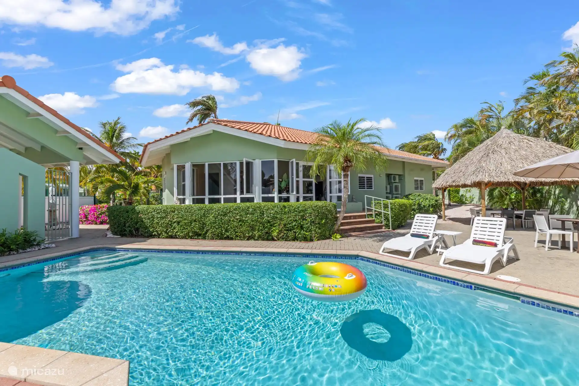 Het hoofdgebouw van Villa Verde, palapa en ligstoelen omringen allemaal het privézwembad en creëren zo je eigen kleine resort thuis.