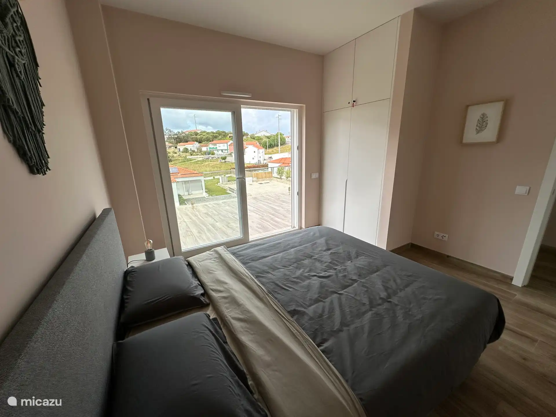 De slaapkamer boven links (komende van de trap. Ook hier met schuifdeur uitkomende op het grote balkon. Het raam is voorzien van een rolluik en een hor als schuifdeur.