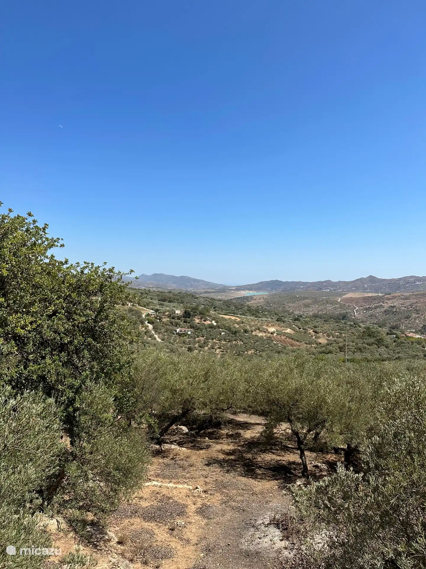 Het uitzicht vanaf de veranda op het stuwmeer van La Viñuela en in de verte de zee.