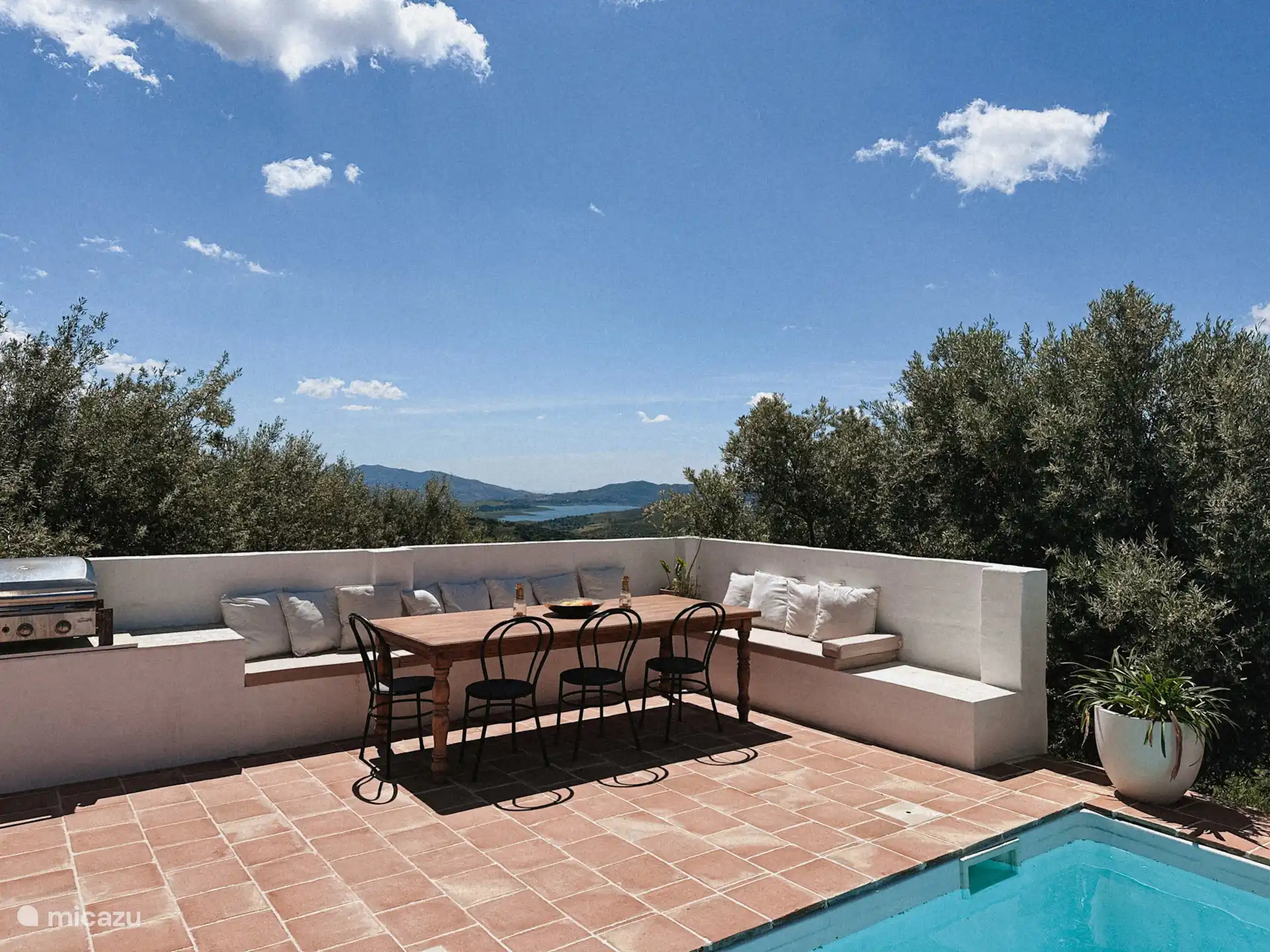 De eethoek op het terras bij het zwembad. In de buitenkeuken staat een bbq voor algemeen gebruik en is een koelkast met drankjes (honesty bar)