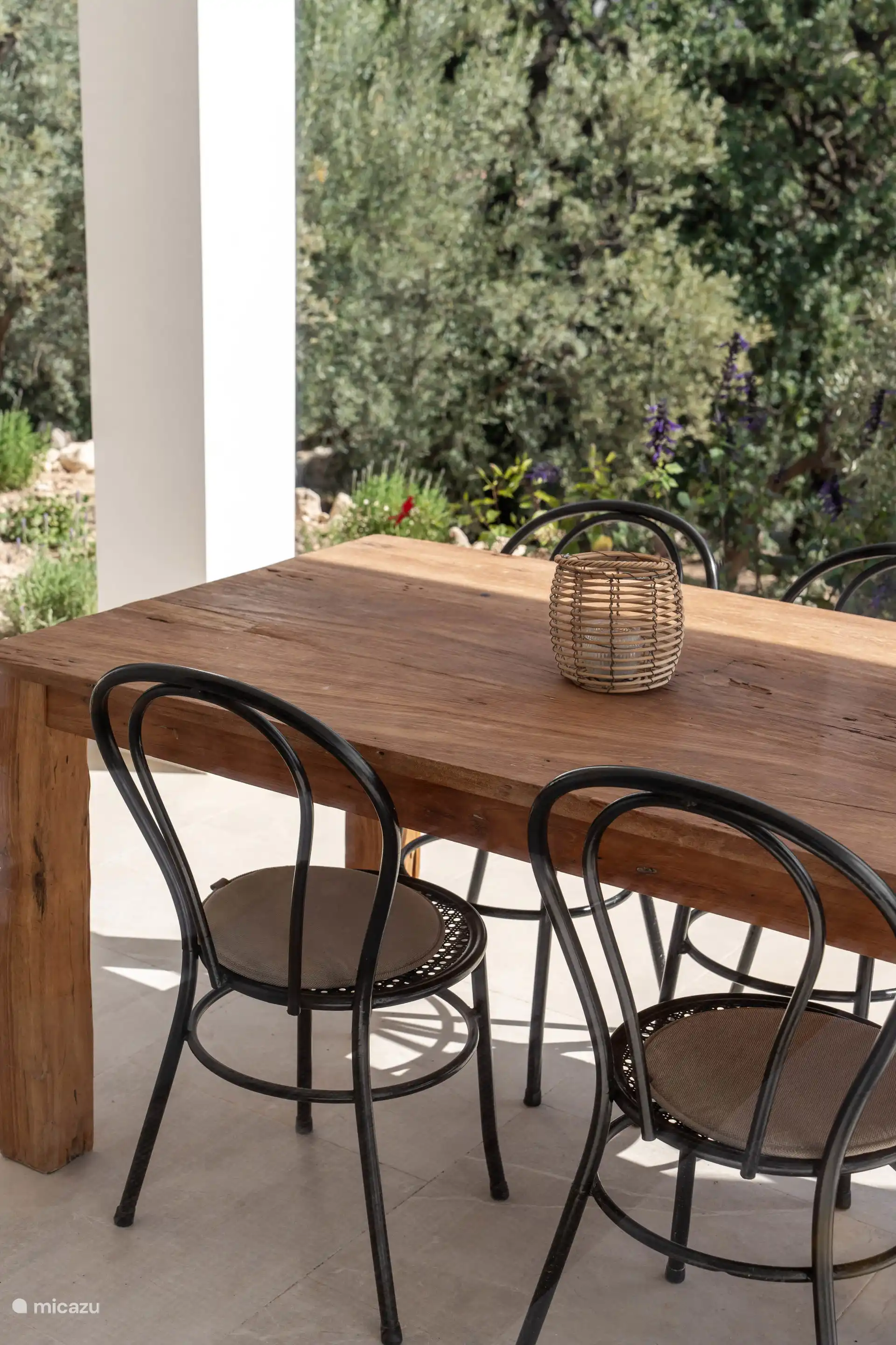 Op de veranda staat een grote eettafel met plek voor 8 personen.