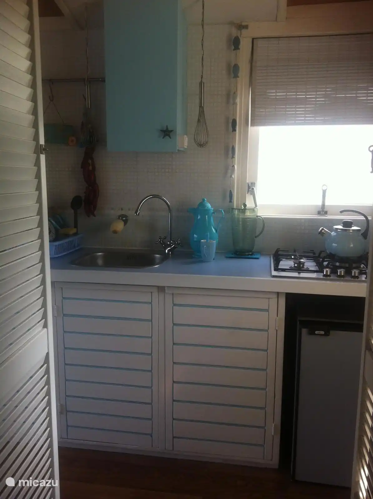 Cuisine avec réfrigérateur et brûleur à gaz.