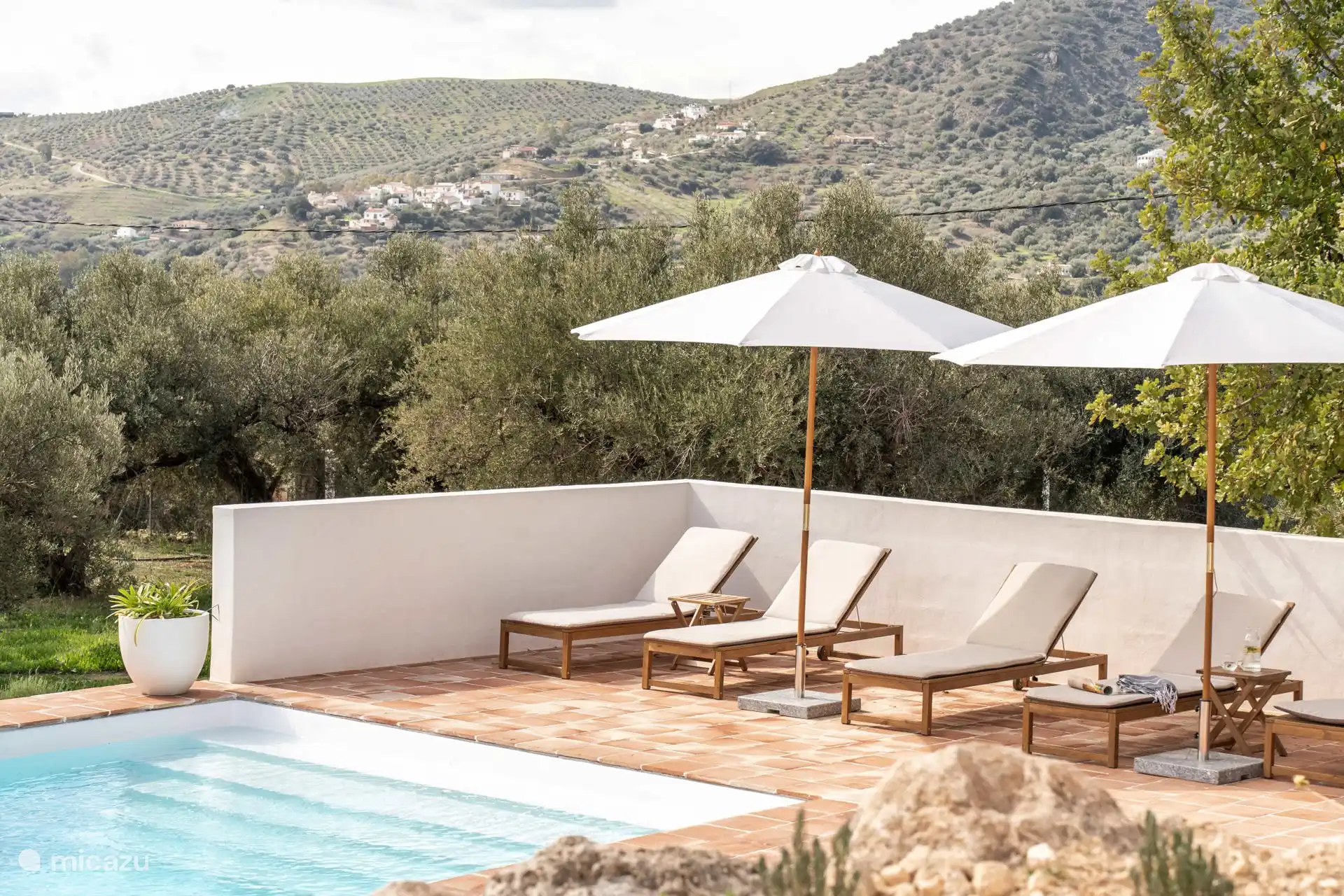 Het terras rondom het zwembad heeft ligbedden en parasols en heeft de hele dag zon.