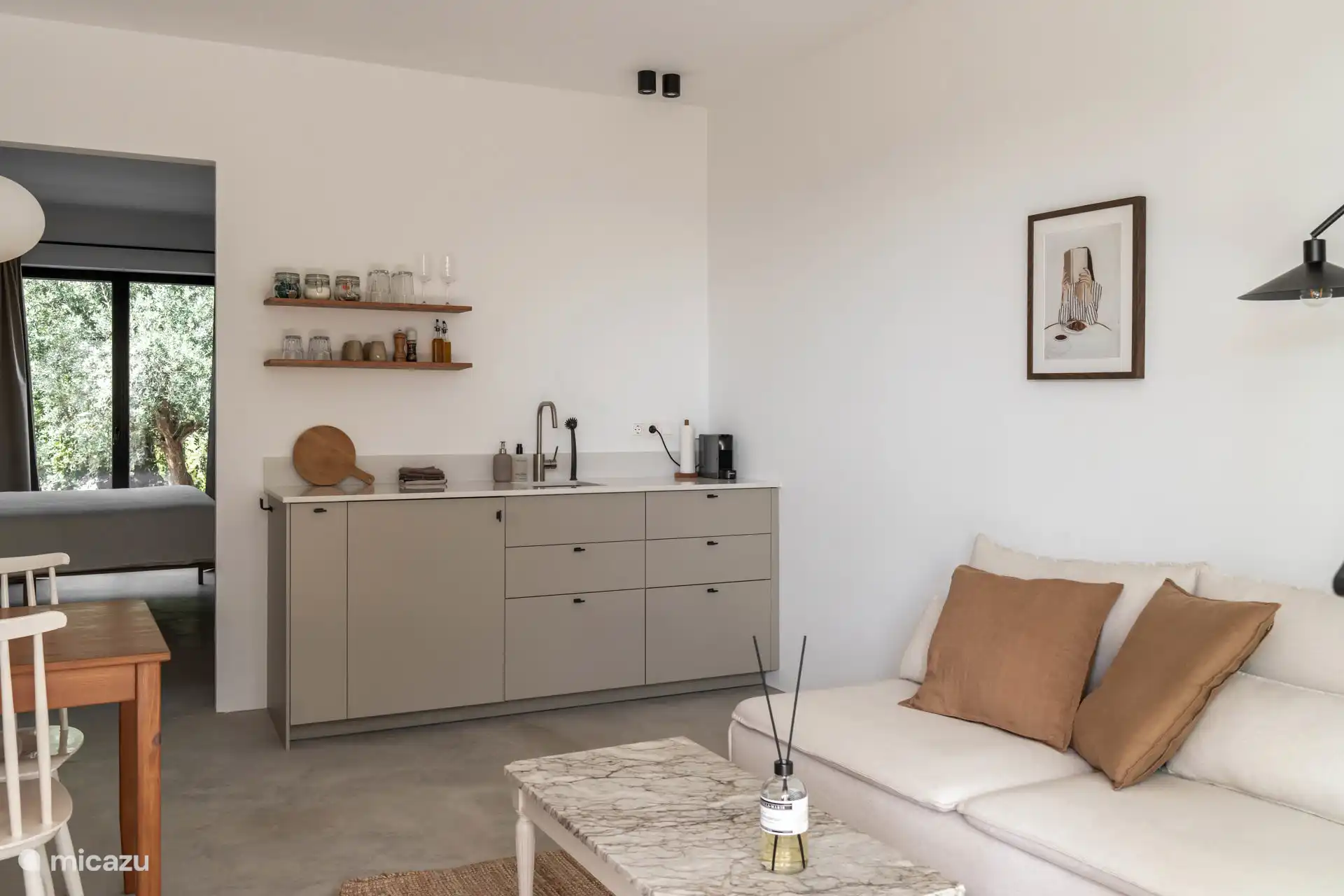 Kleinere woonkamer met een kitchenette. Deze woonkamer grenst aan een slaapkamer met badkamer ensuite en kan worden gescheiden door een deur van de andere (grote) woonkeuken.