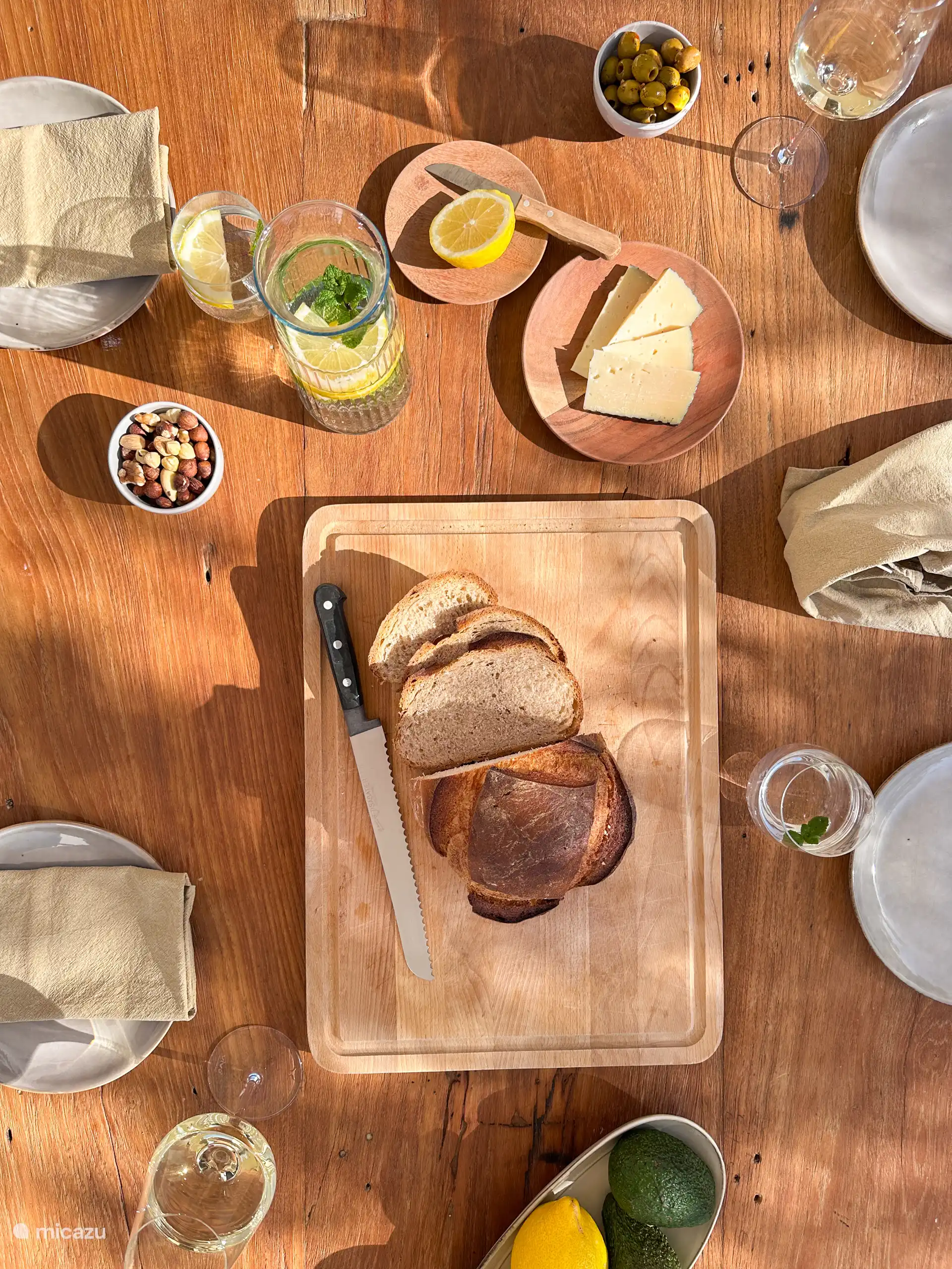Aan de voorzijde van het huis zit een lange veranda waar een grote eettafel staat. De perfecte plek om 's ochtends in de zon te ontbijten of een borrel te drinken