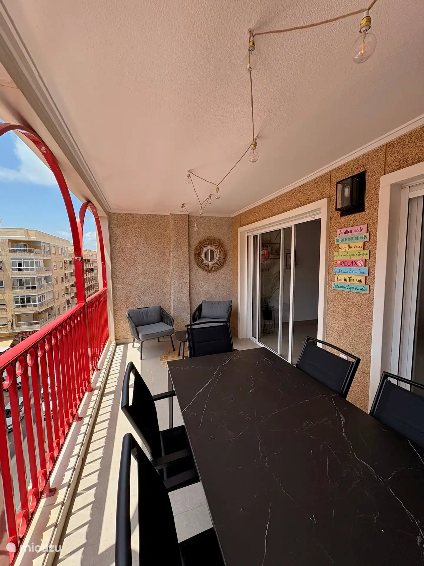 Terras aanpalend aan keuken en eetplaats met 2 lounge zetels, een eettafel en 6 stoelen