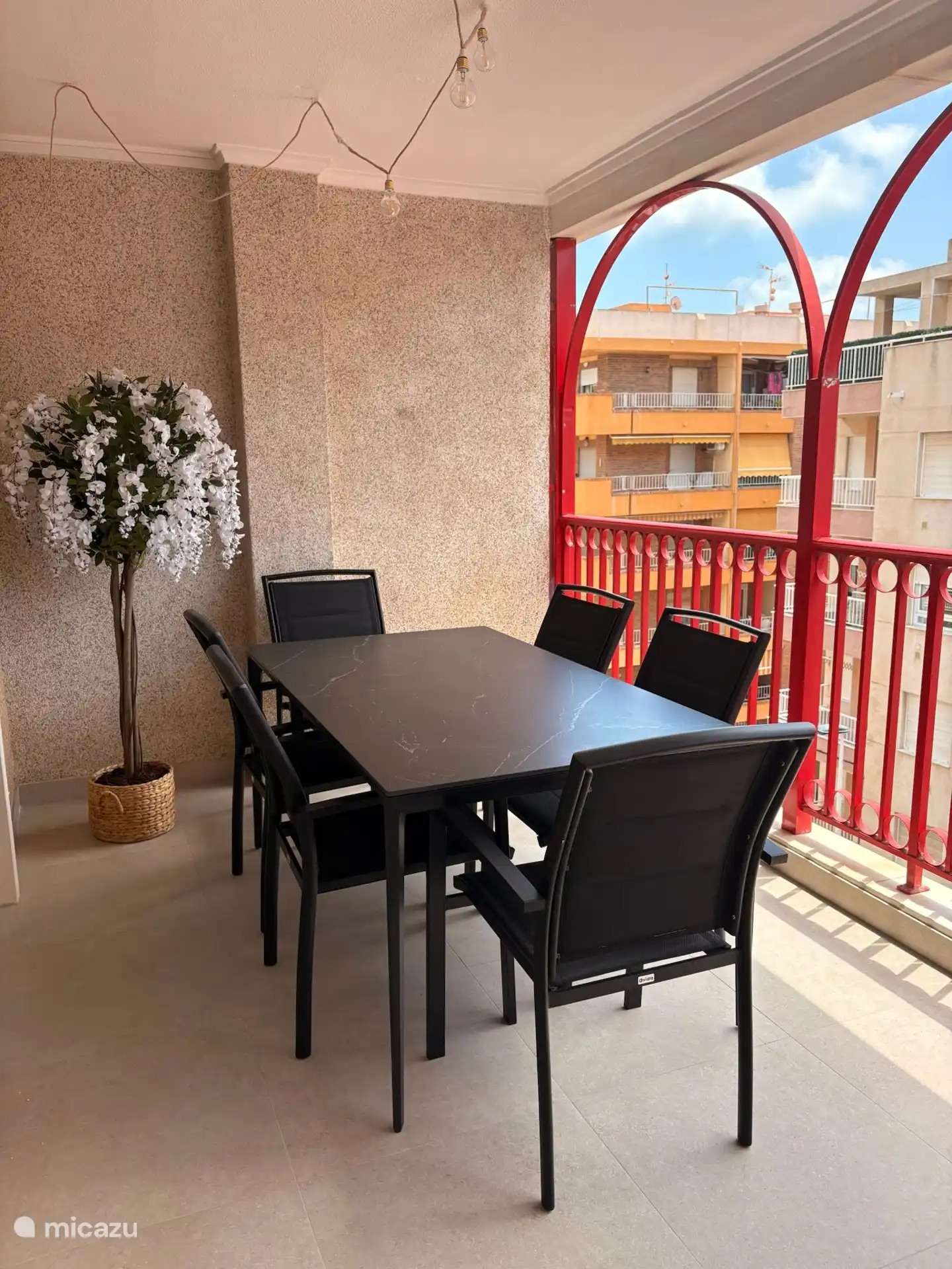 Terras aanpalend aan keuken en eetplaats met 2 lounge zetels, een eettafel en 6 stoelen