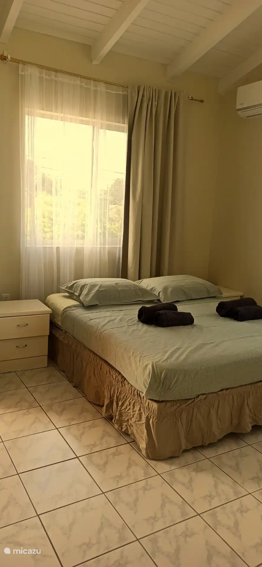 Chambre principale confortable avec climatisation et balcon. 