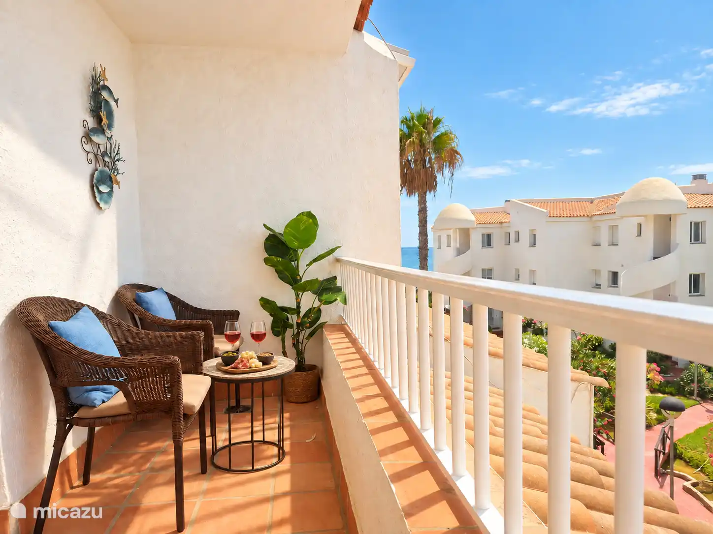Balcony on the bedroom side (west side), with two chairs, a table and a bench.