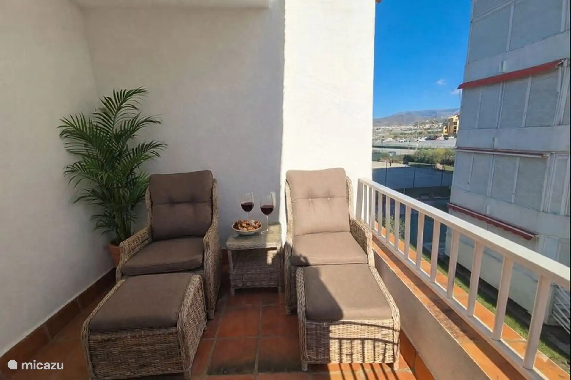 Hetzelfde balkon, met aan de andere kant twee  loungestoelen.