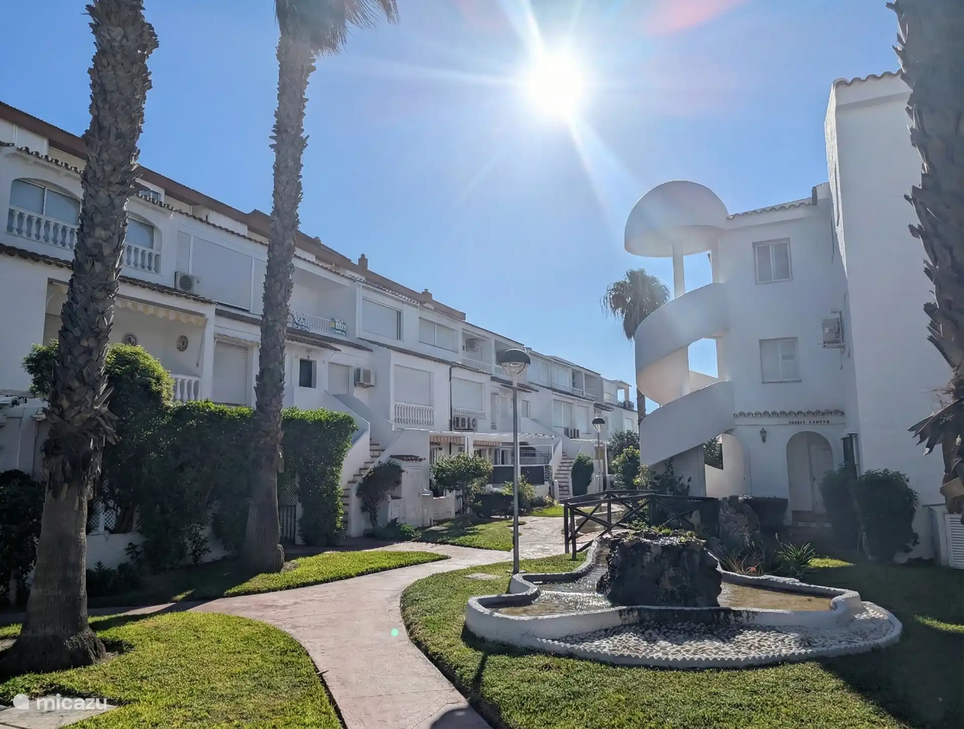 De binnentuin van Laguna Beach met het paadje waar het appartement (aan de linkerkant) aan ligt. 50 meter verderop is de toegang naar de boulevard en het strand. 
