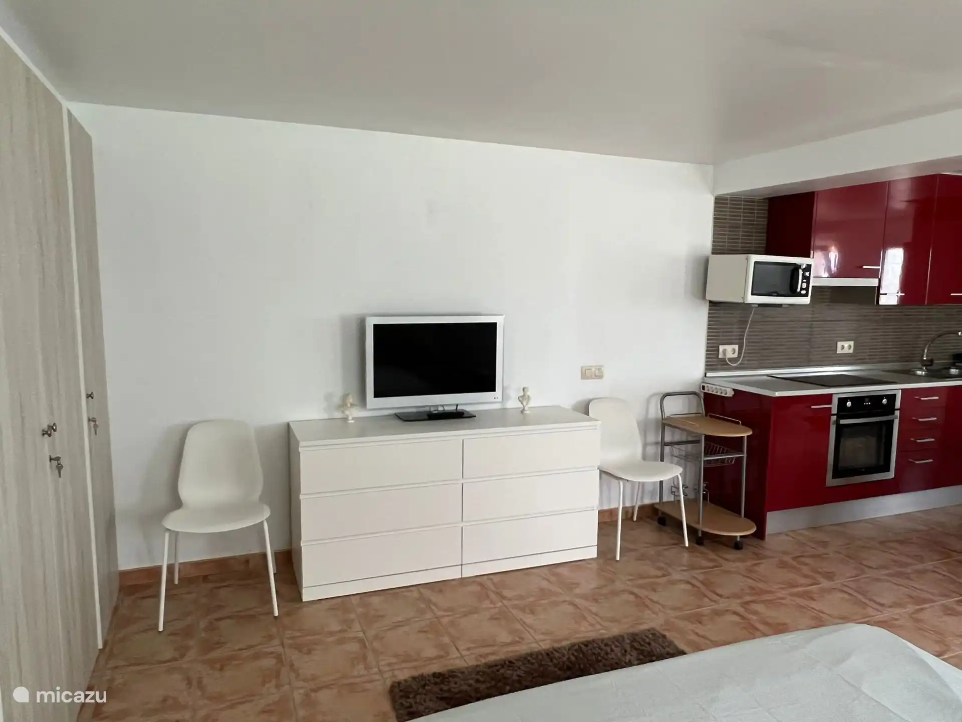 Kast met veel lades om als opslag te gebruiken, met tv; zichtbaar vanaf het bed of vanuit de woonkamer