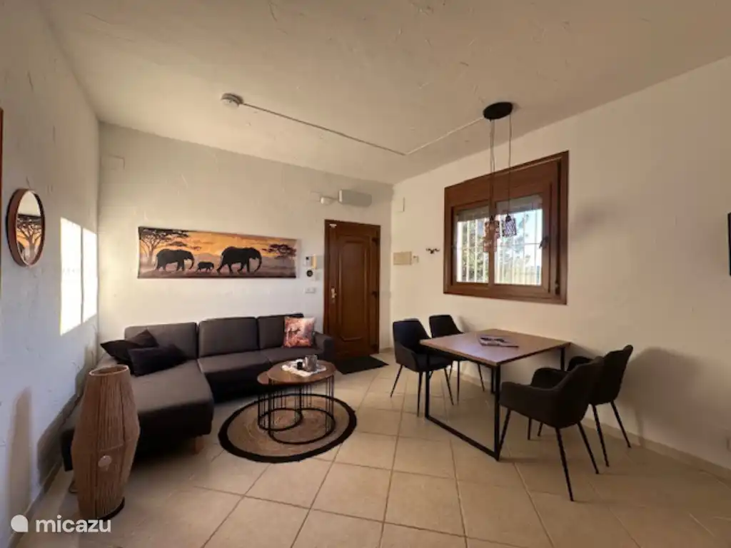 Salon où le canapé d’angle avec table basse. De plus, la table à manger avec 4 chaises. Dans cette pièce, vous trouverez aussi la télévision. Depuis la pièce, on a une vue magnifique sur le paysage montagneux.