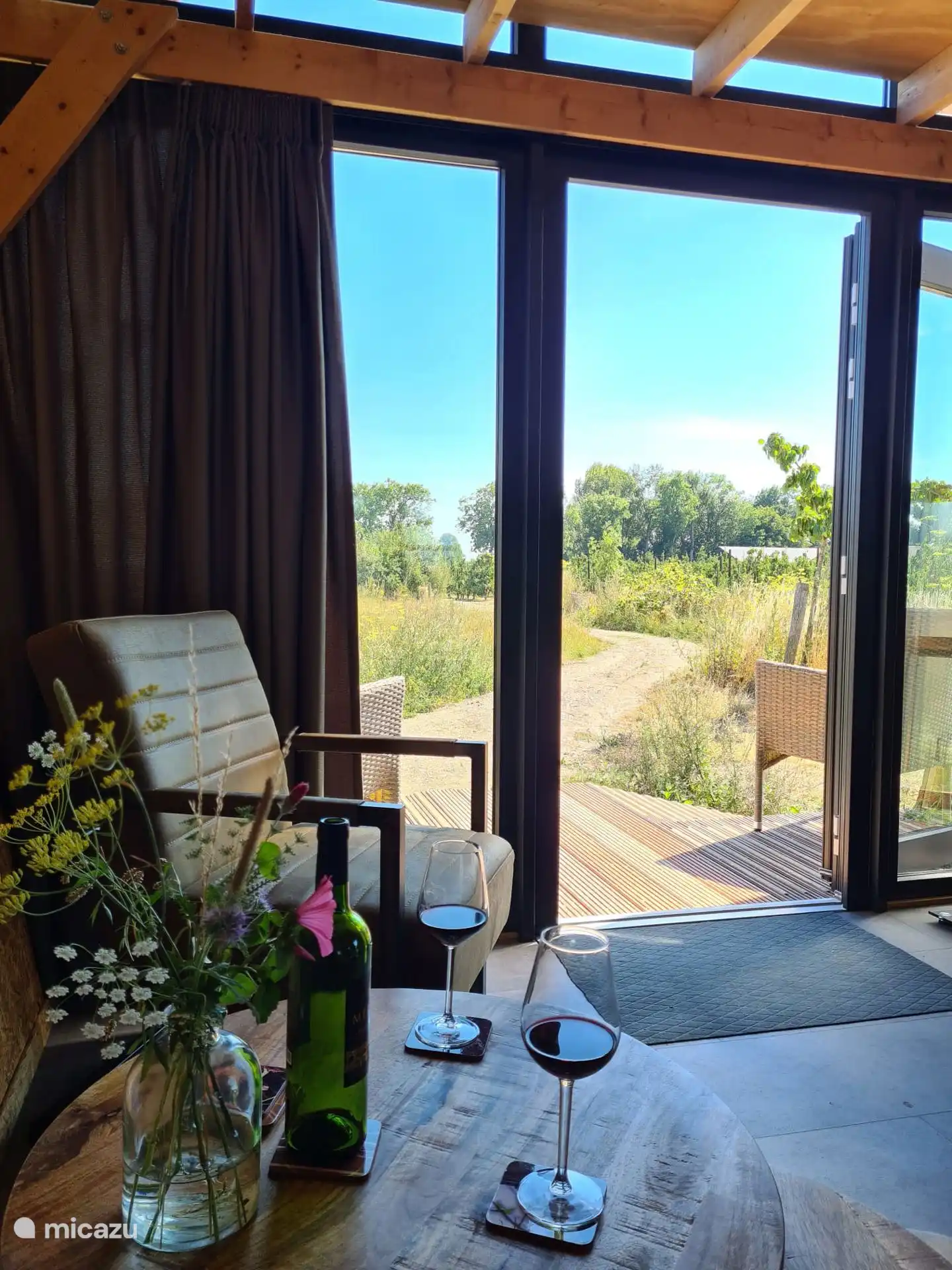 zicht naar buiten aan de voorzijde met op de achtergrond de minicamping