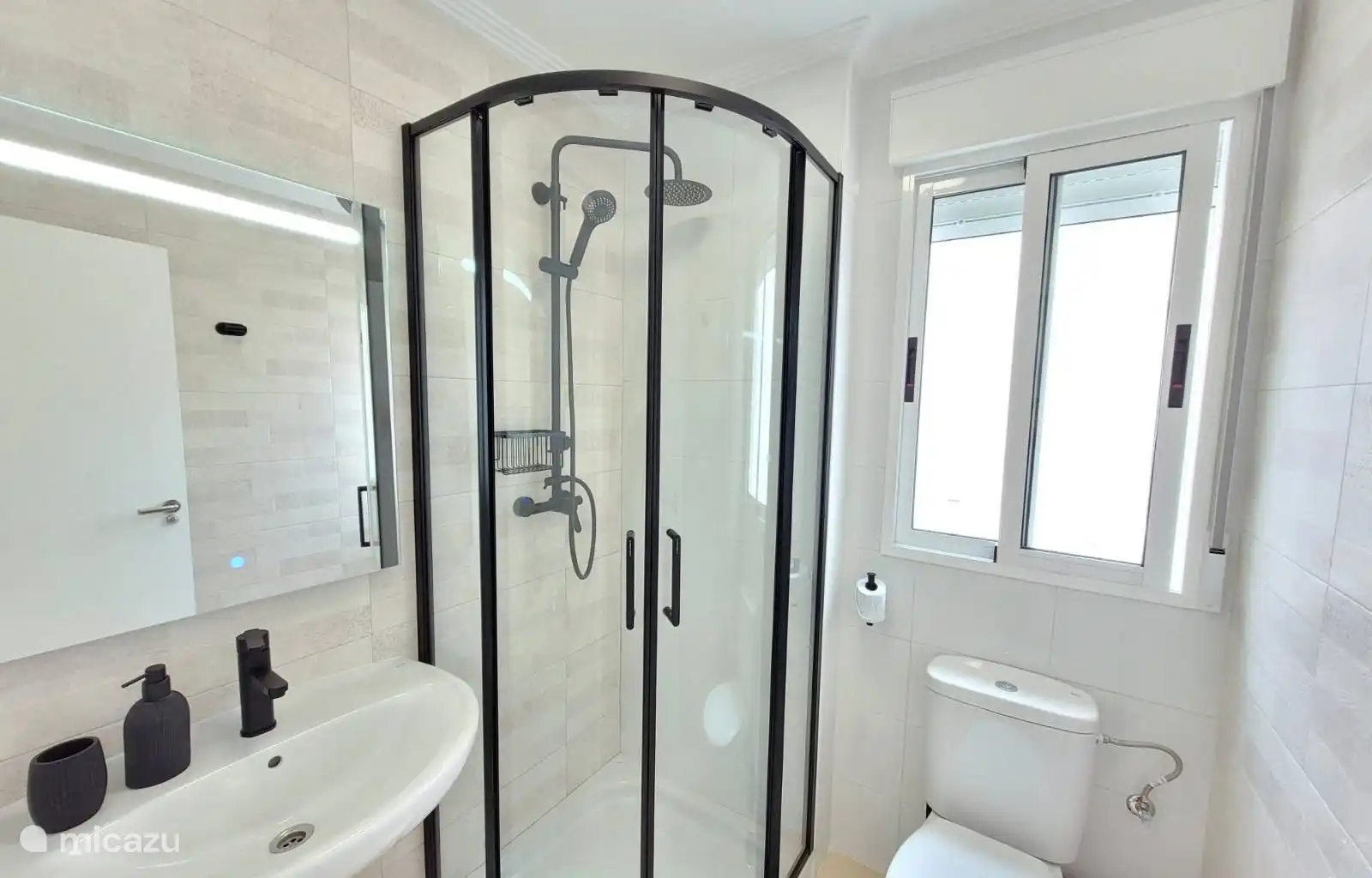 Salle de bain au rez-de-chaussée avec douche et toilettes. 